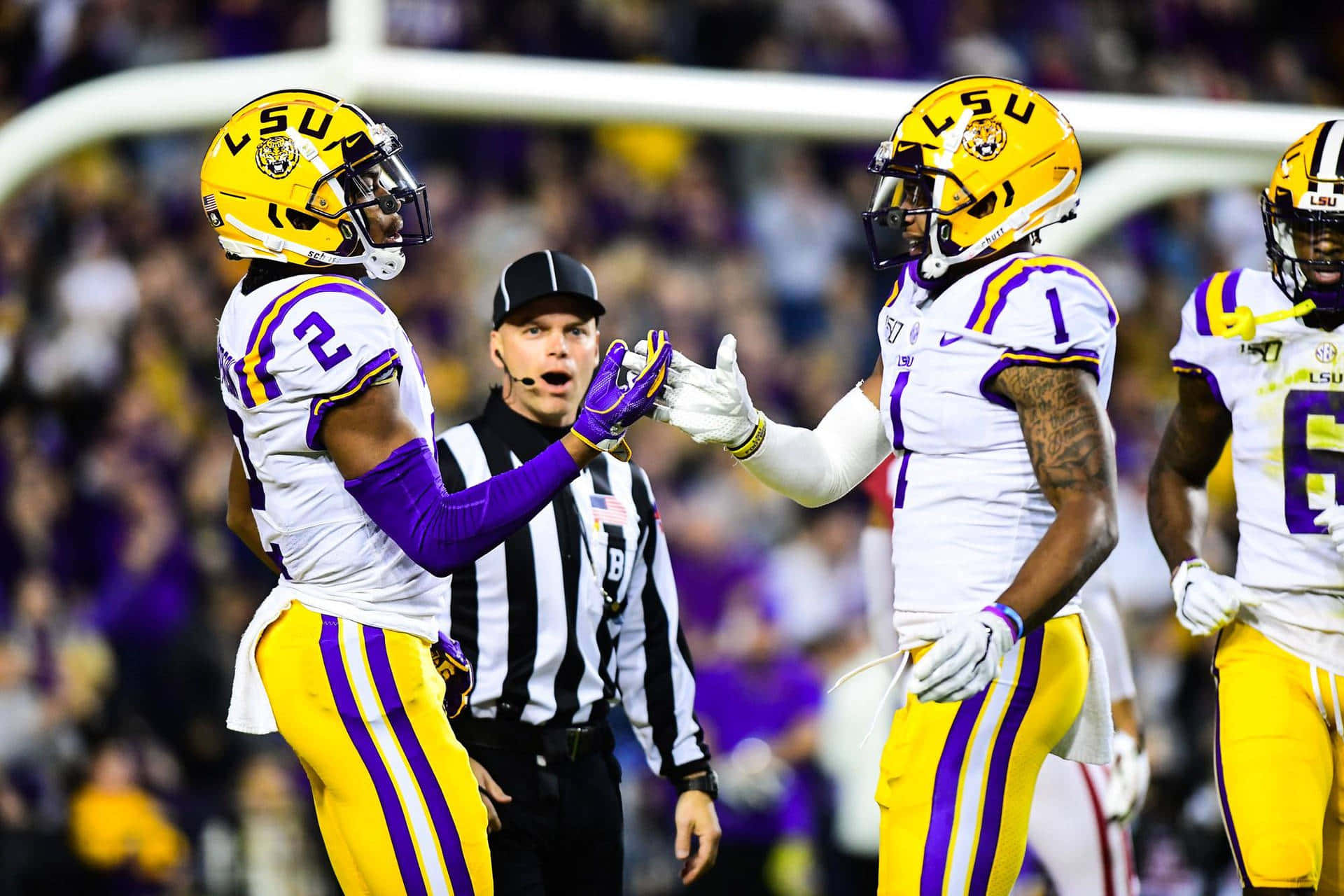 Lsu Football Players Are Celebrating After A Touchdown Background