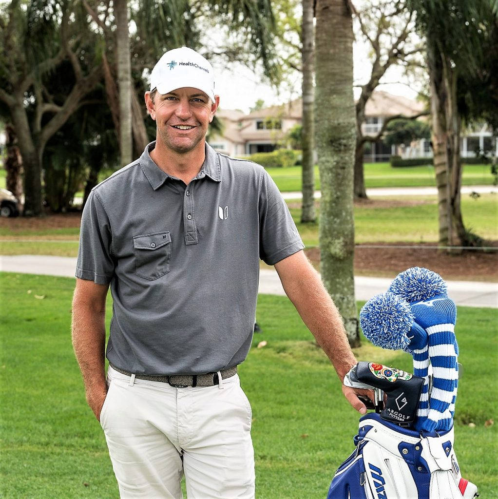 Lucas Glover Poised On The Golf Field With His Golf Bag Background