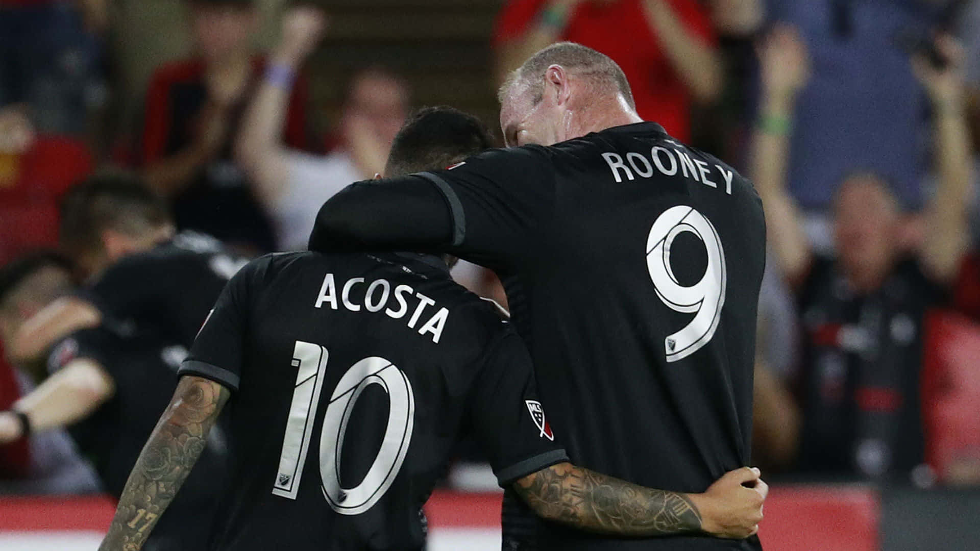 Luciano Acosta And Team Captain Rooney Background