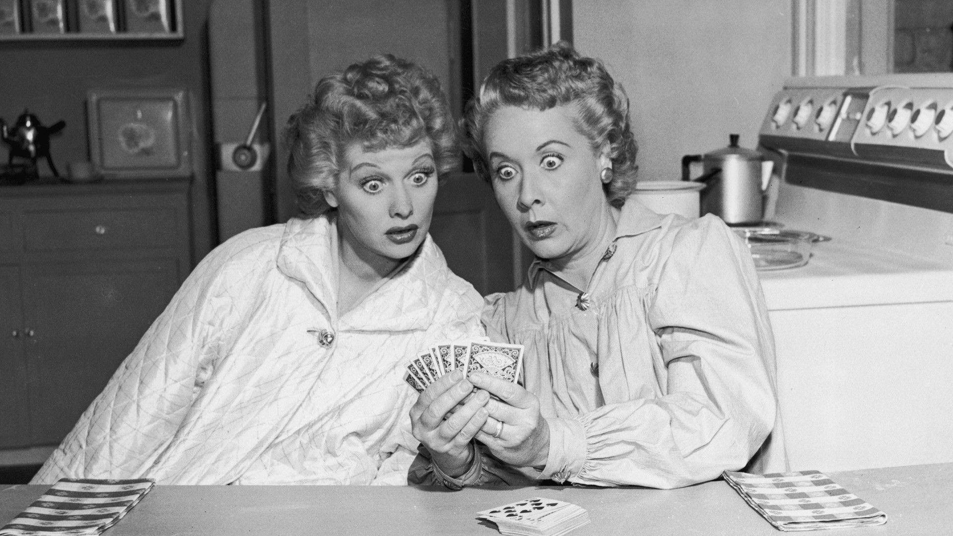Lucille Ball And Vivian Vance Engaged In A Friendly Card Game Background