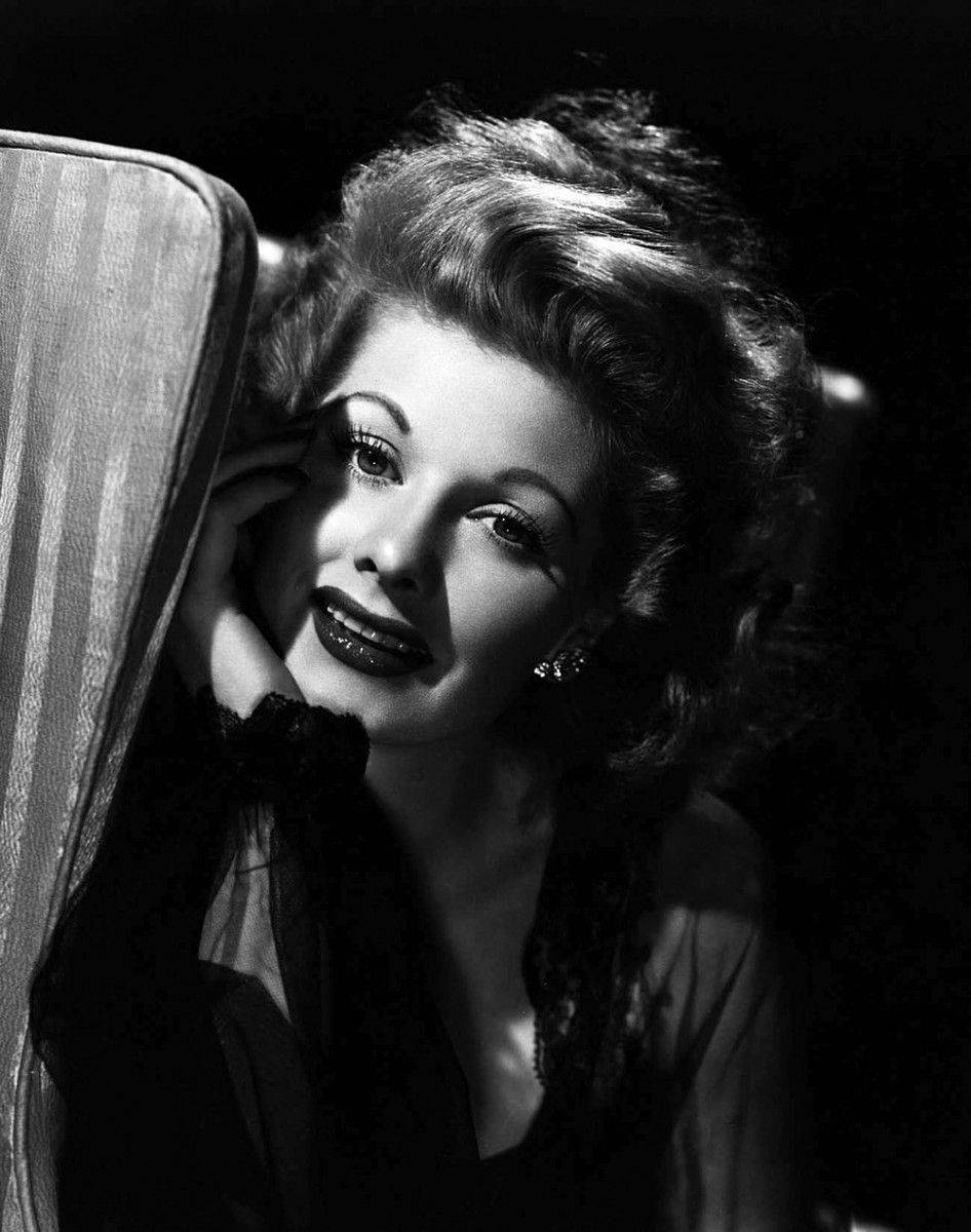 Lucille Ball Posing Behind A Mirror Background
