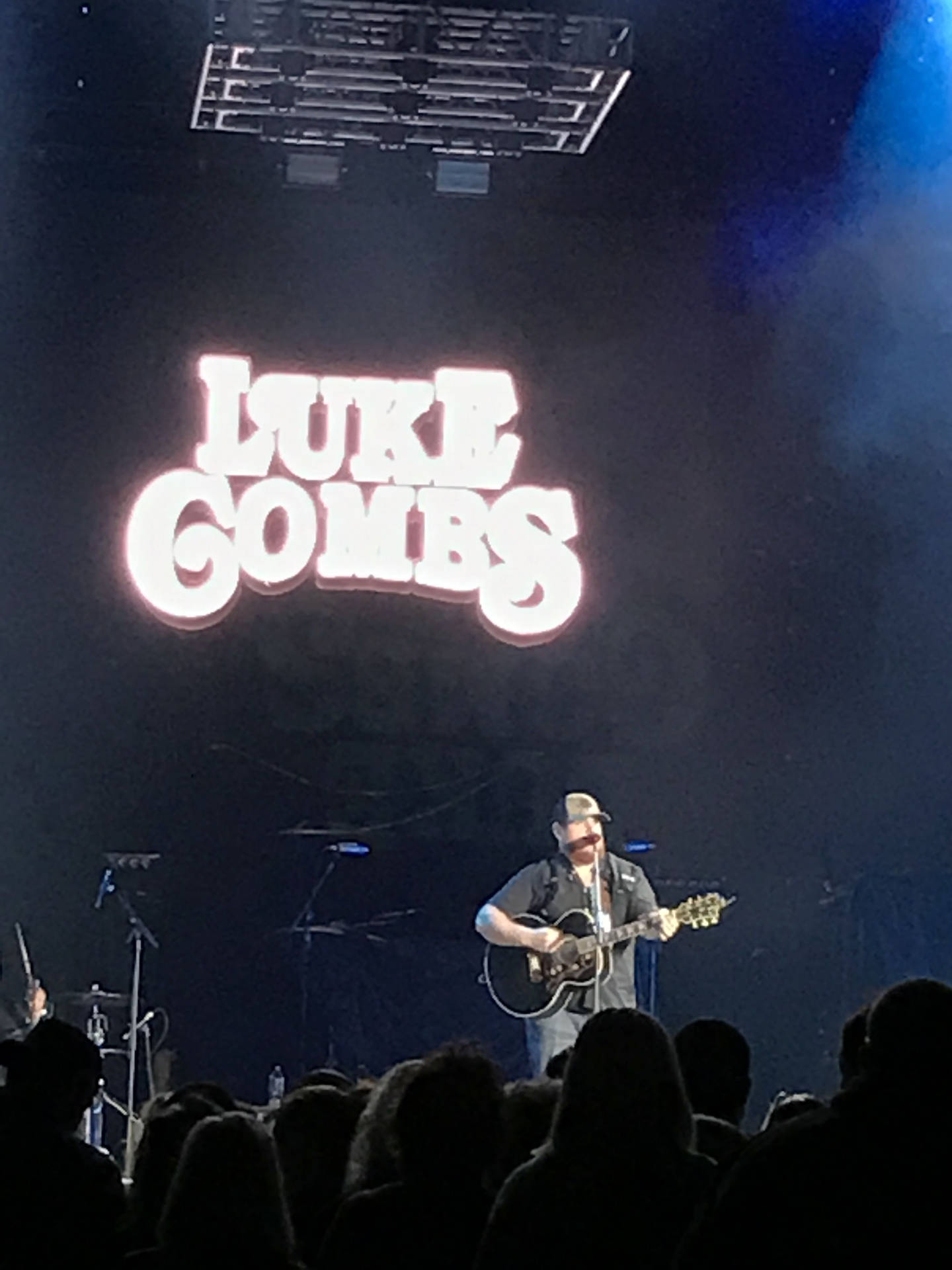 Luke Gomes On Stage At A Concert Background