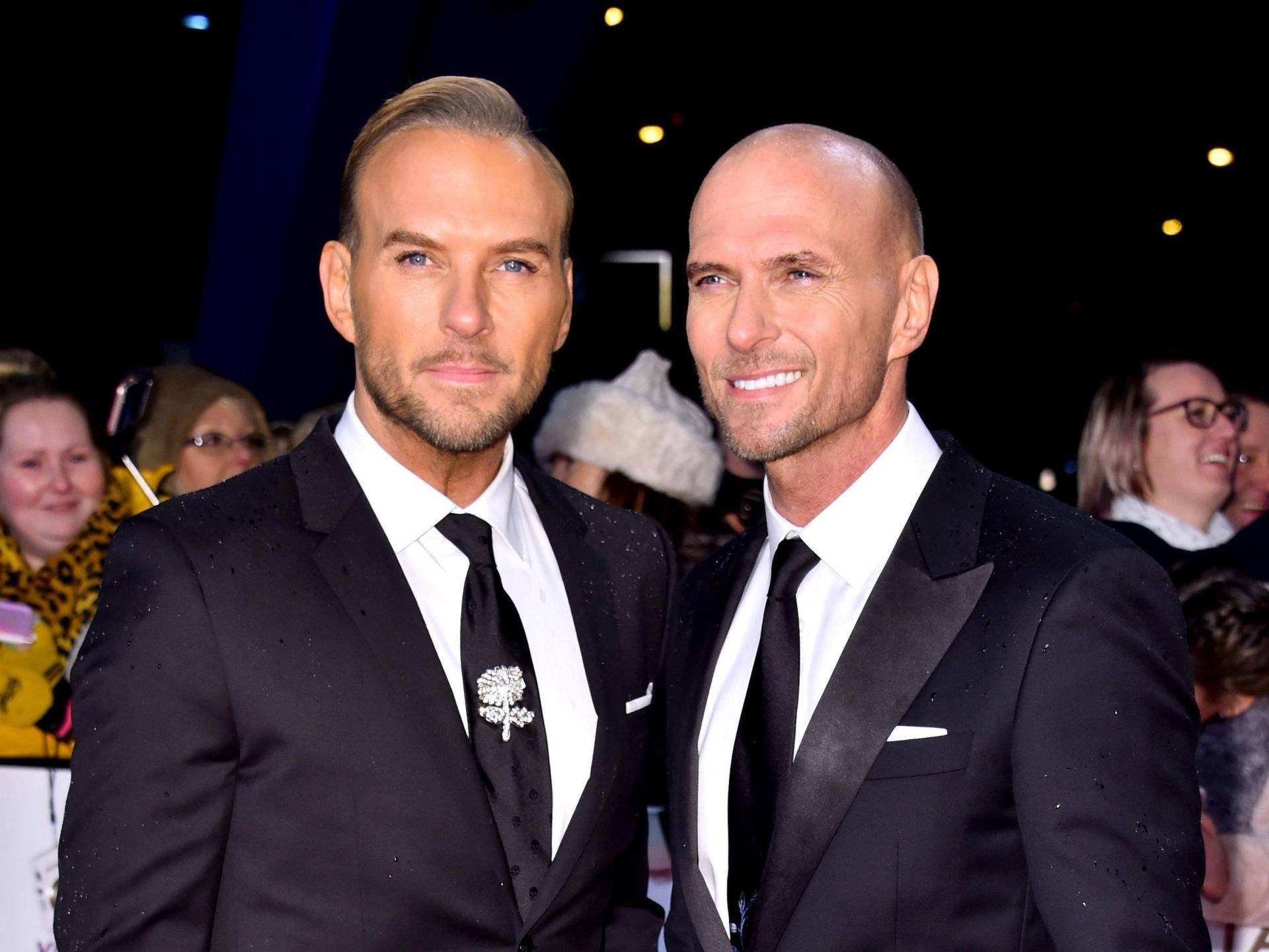 Luke Goss And Matt Goss In Suits Background