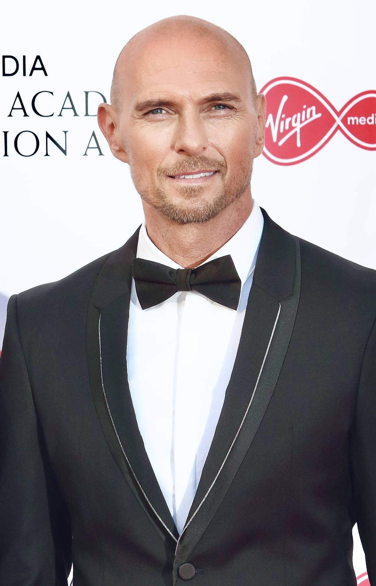 Luke Goss In A Suit And Ribbon