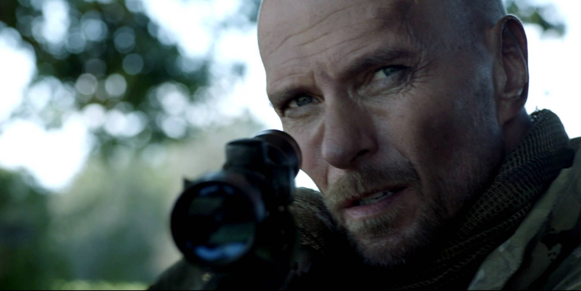 Luke Goss Pointing A Rifle Gun Background