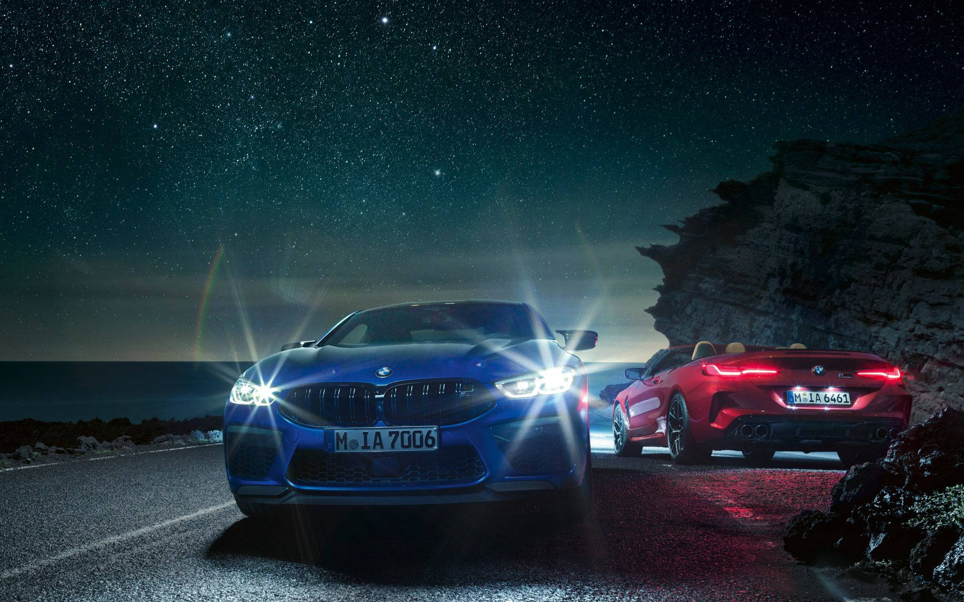 Luxurious Blue Bmw Driving At Night Background