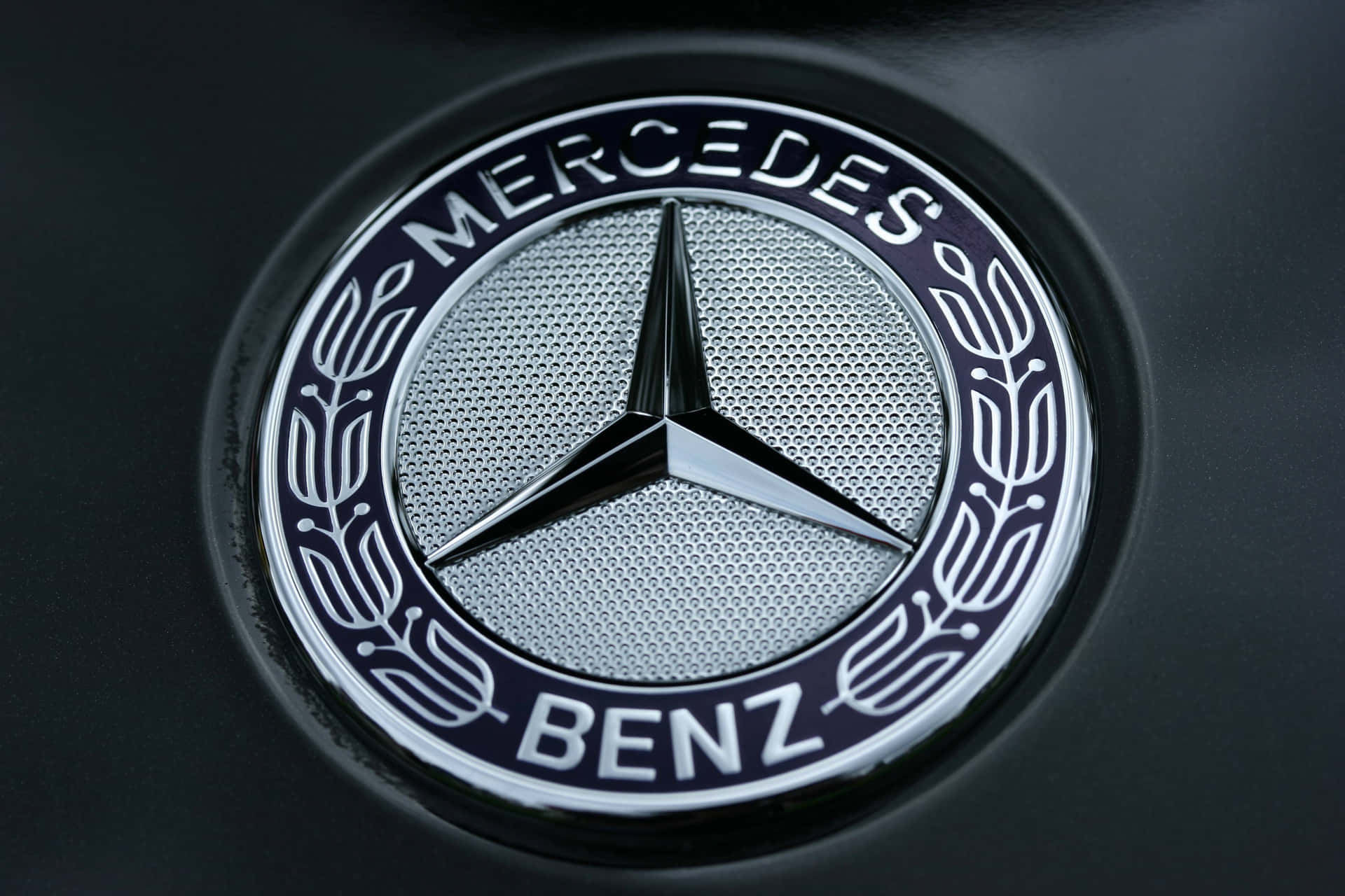 Luxurious Car Logo - Close-up View Of A Prestigious Car Emblem Background