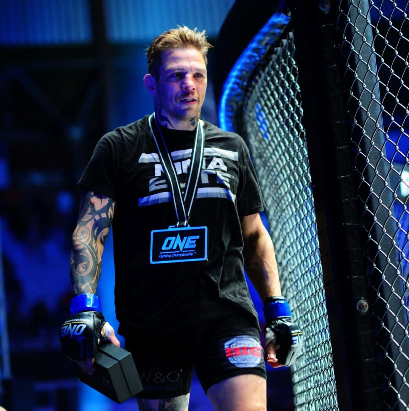 M M A Fighter Beside Cage Octagon Background