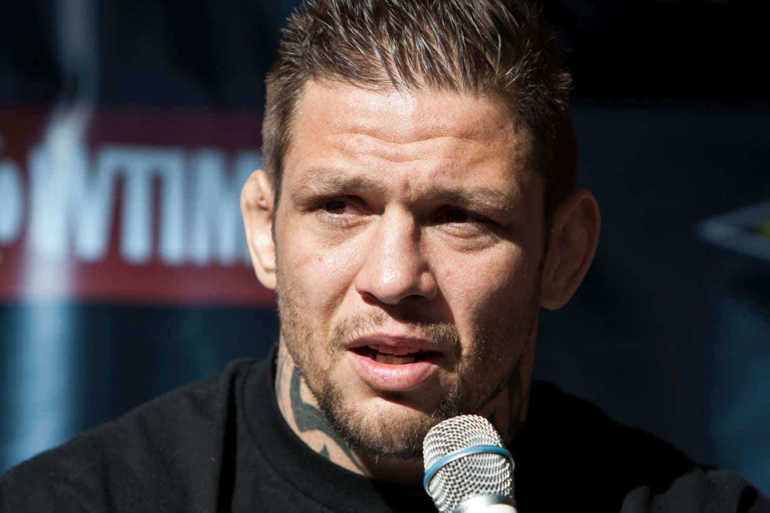M M A Fighter Speakingat Press Conference Background
