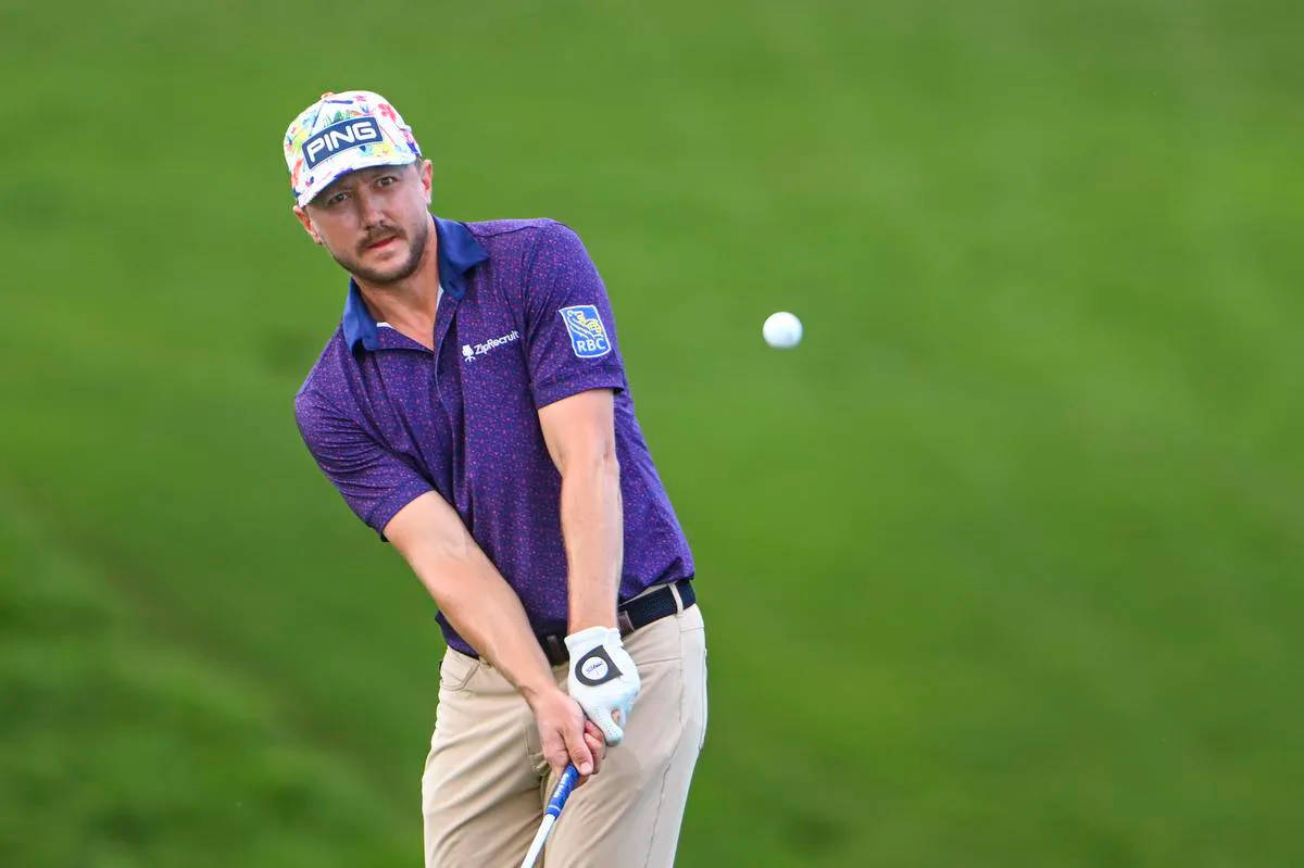 Mackenzie Hughes Looking At Golf Ball Background