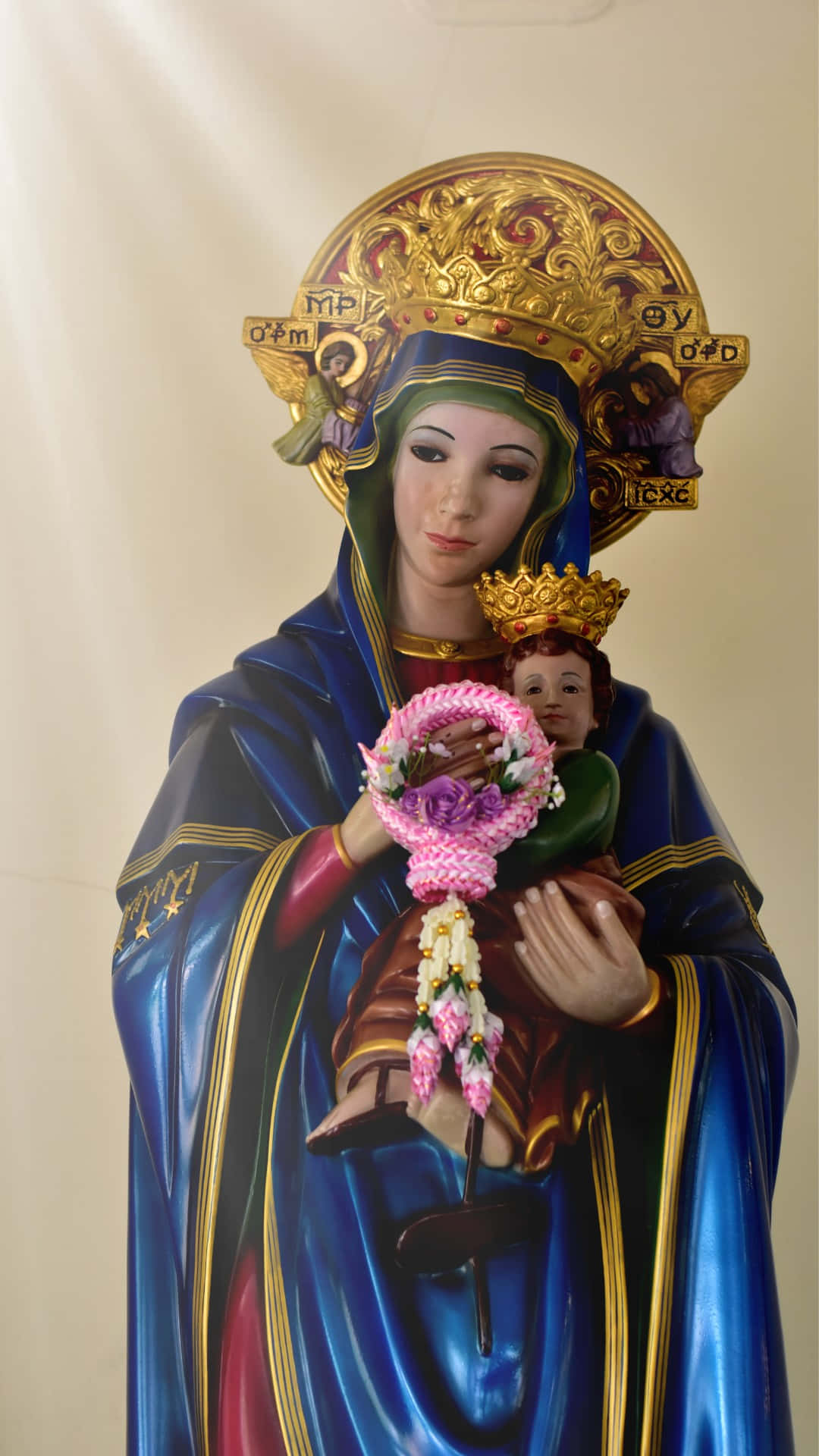 Madonnaand Child Statuewith Floral Bouquet Background