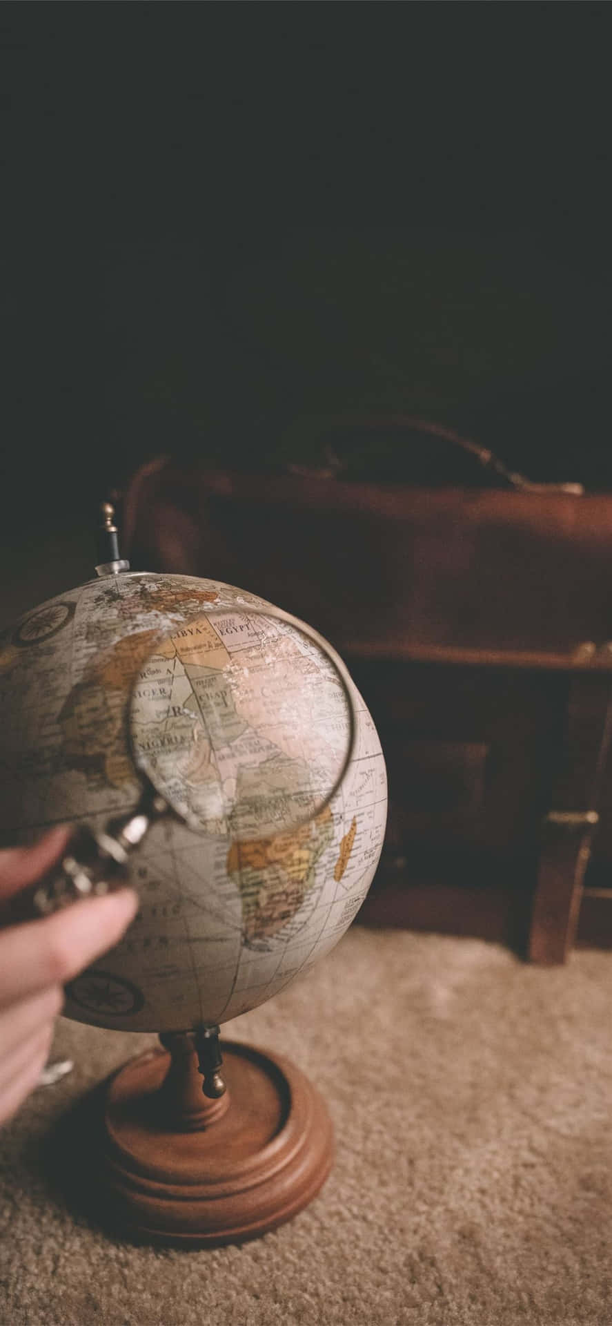 Magnifying Glass On A Mini Globe Background