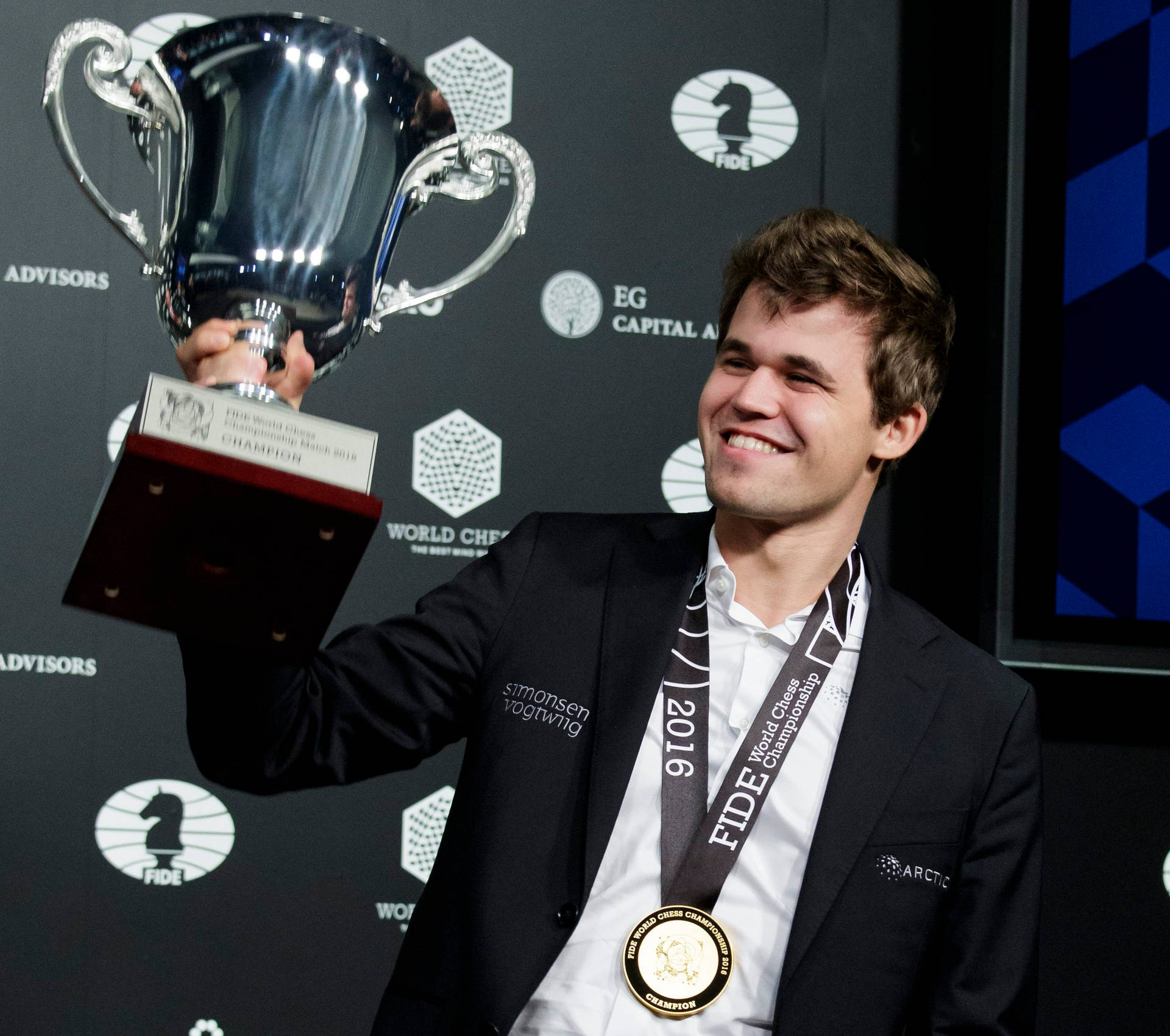 Magnus Carlsen Celebrating Victory At A Chess Tournament Background