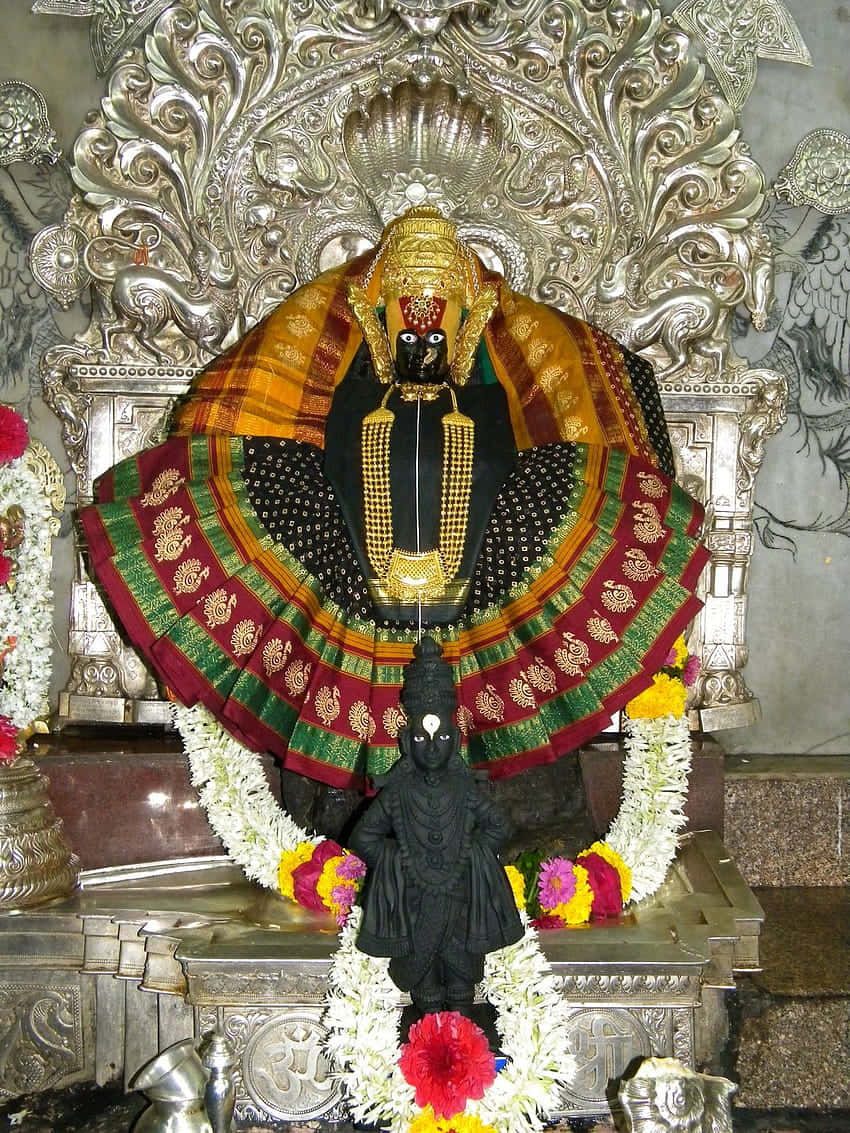 Mahalakshmi Statue Adornedin Temple Background