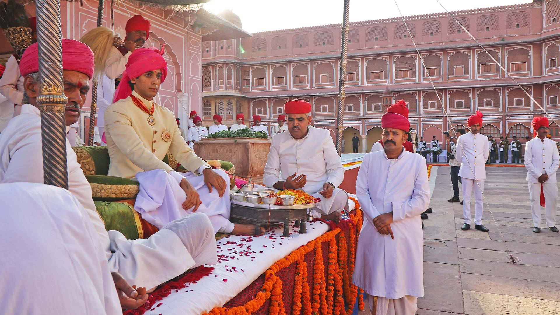 Maharaja Padmanabh Singh Admiring The Rich Heritage Of City Palace In Jaipur Background