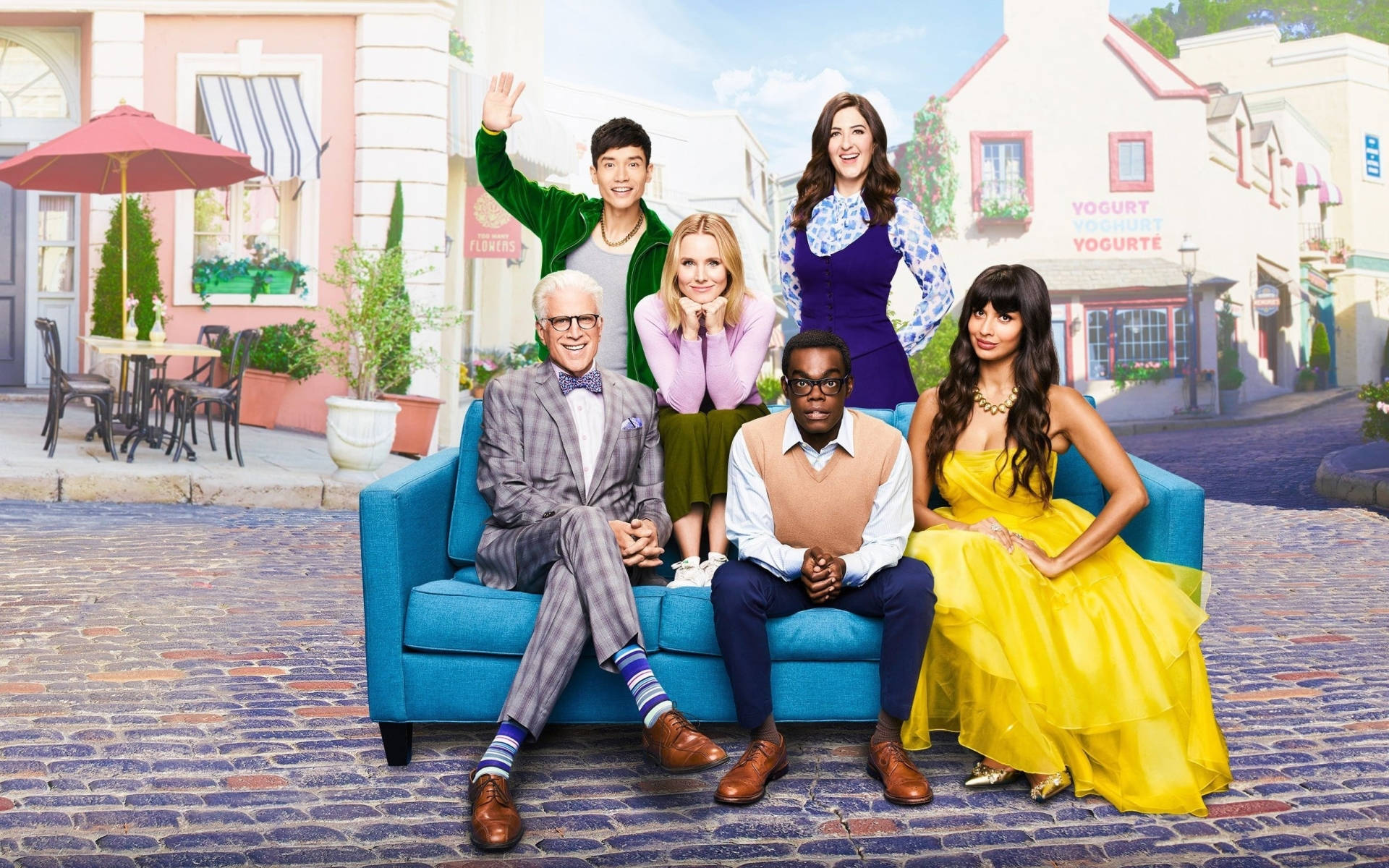 Main Cast Of The Good Place Posing On A Stylish Blue Couch Background
