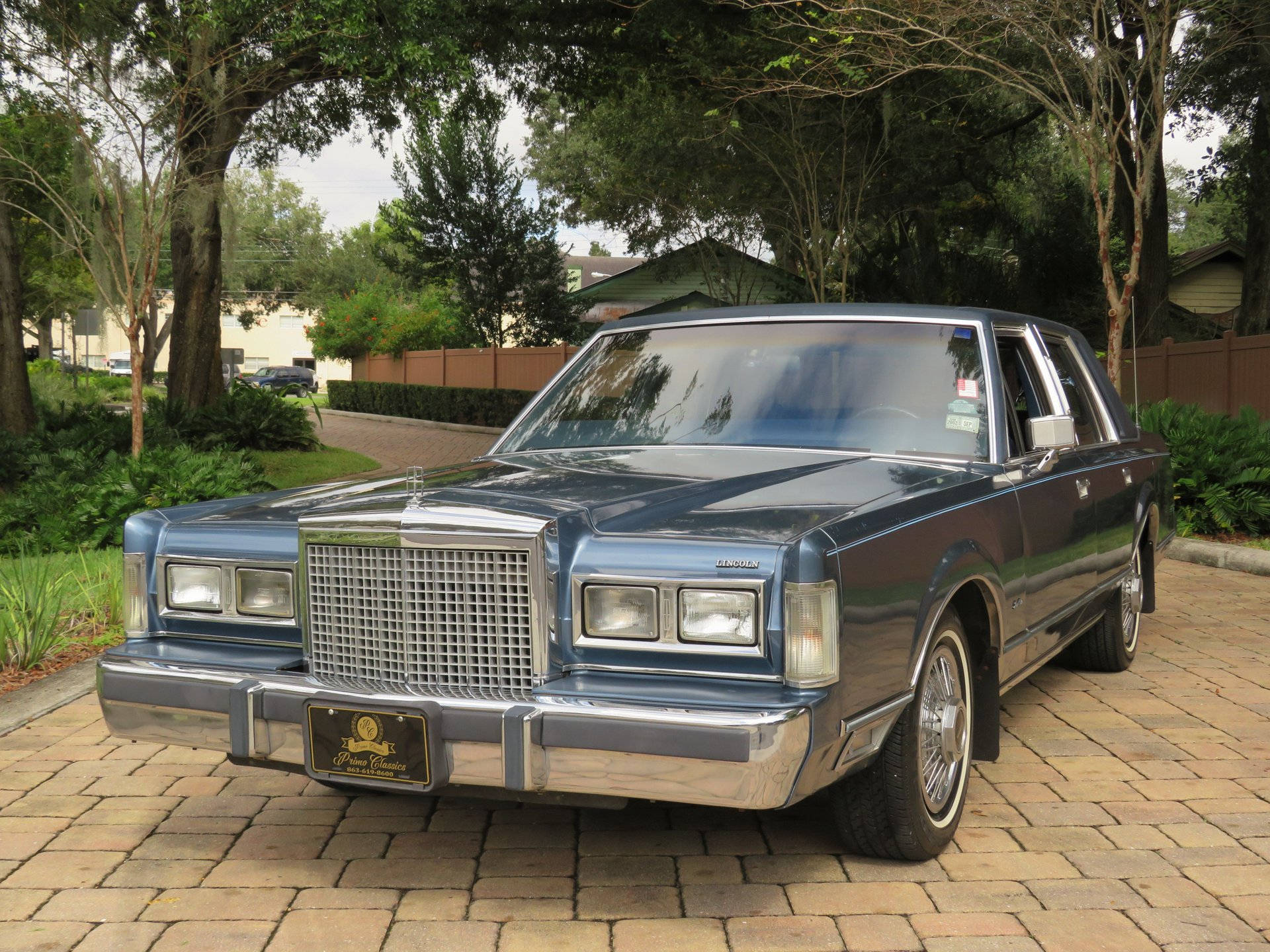 Majestic 1986 Lincoln Town Car Parked On A Paved Driveway Background