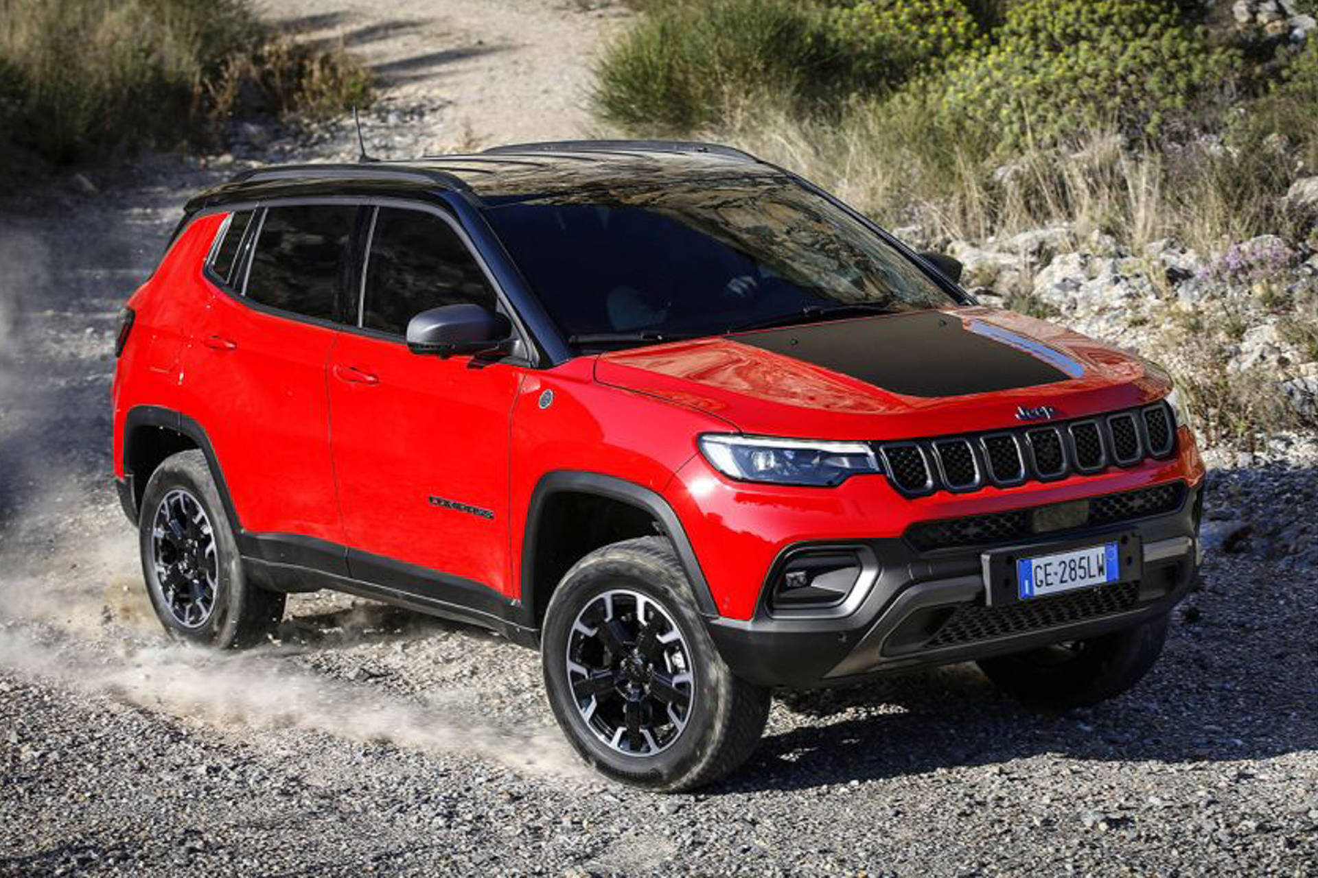 Majestic Black And Red Jeep Compass Dominating The Gravel Road Background