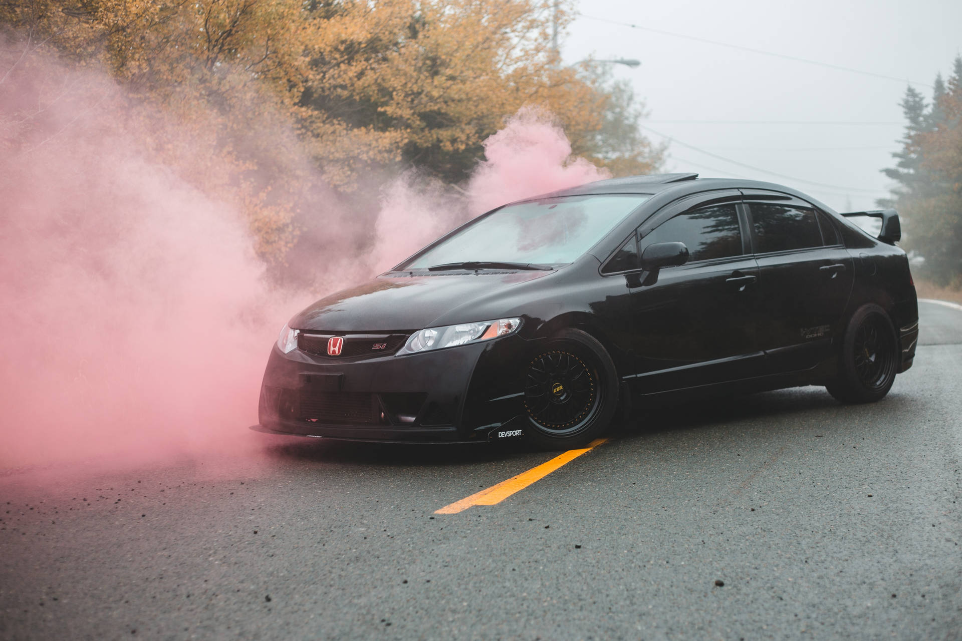 Majestic Black Sports Car Amidst Pink Smoke Background