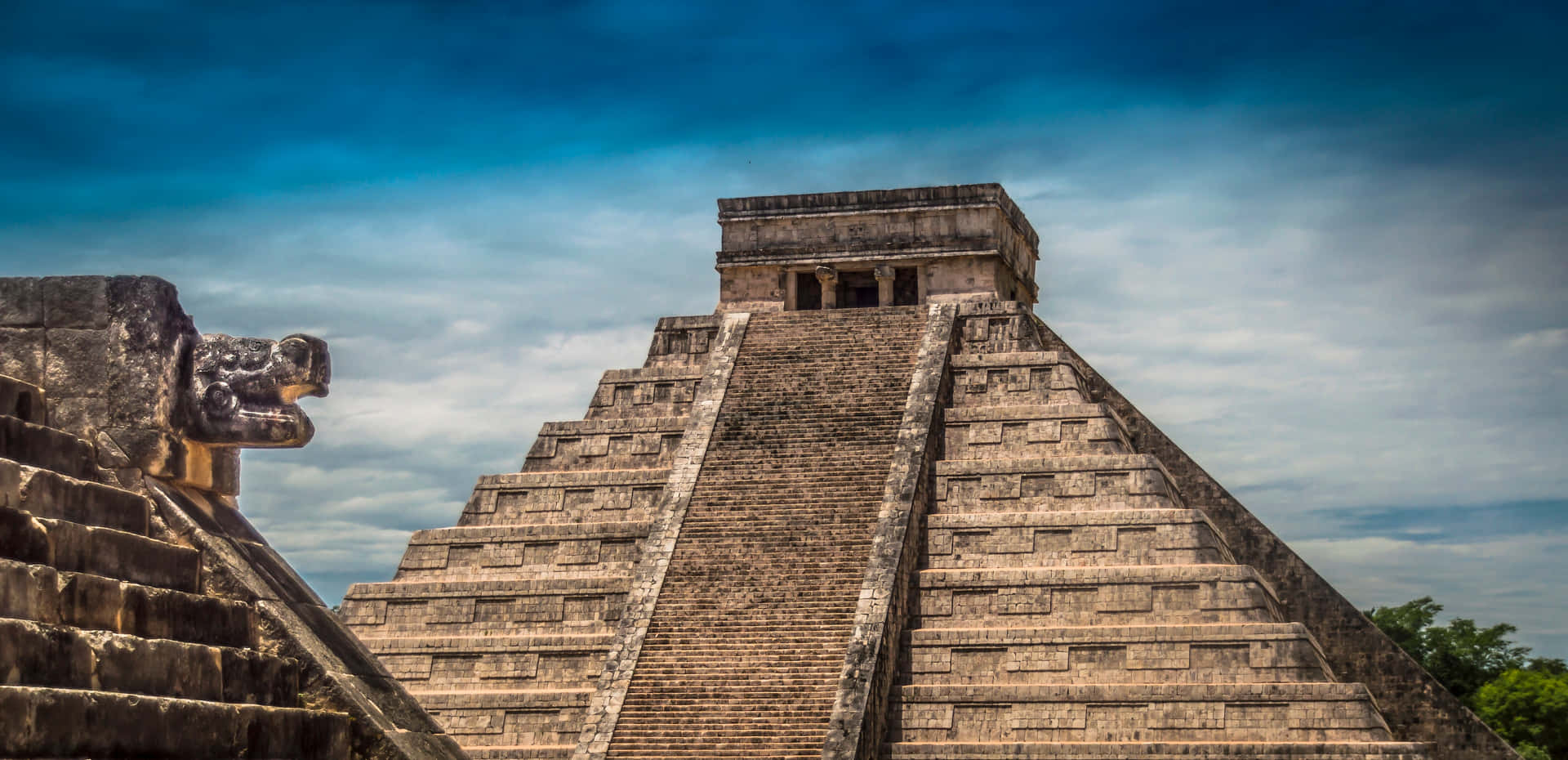 Majestic Chichen Itza Under The Cloudy Blue Sky Background