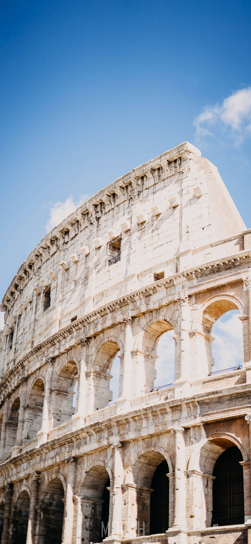 Majestic Colosseum Under Clear Blue Sky Background