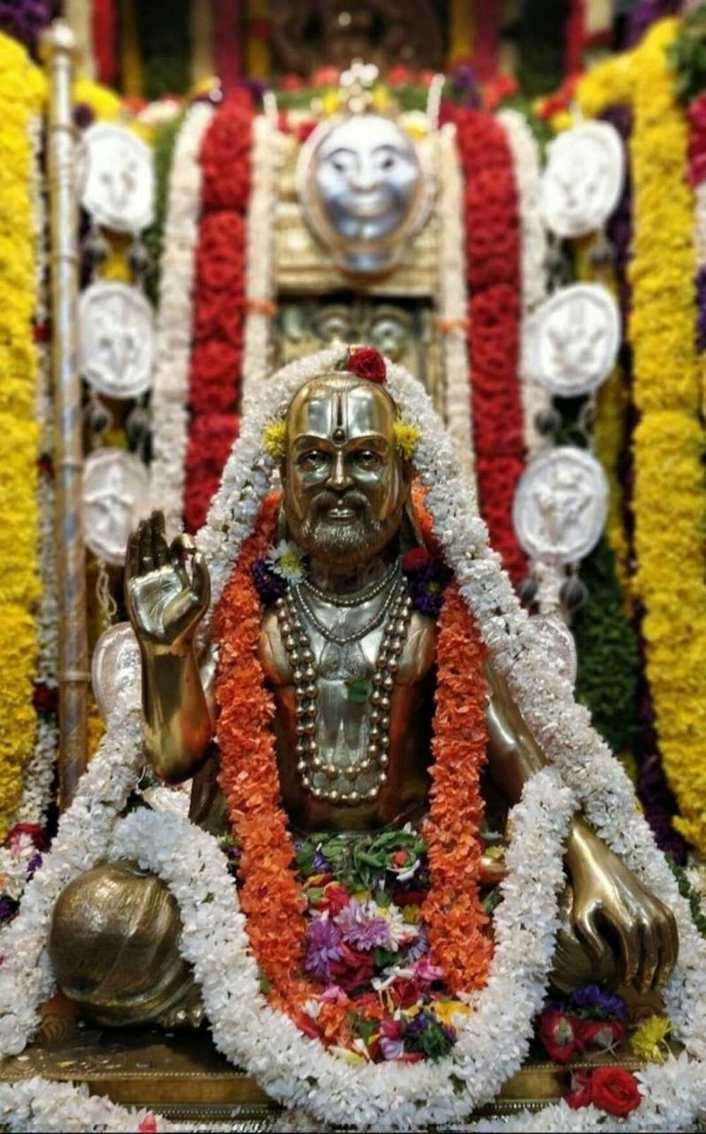 Majestic Golden Statue Of Raghavendra Adorned With Floral Garlands