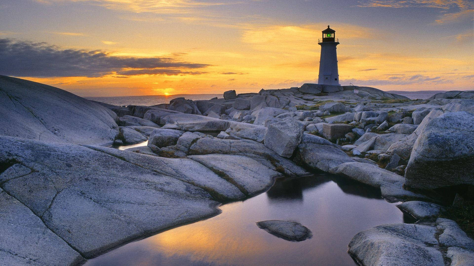 Majestic Lighthouse Illuminating The Shoreline Background