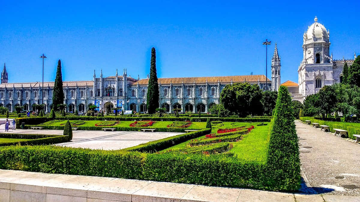 Majestic Mosteiro Dos Jeronimos On A Bright Sunny Day Background
