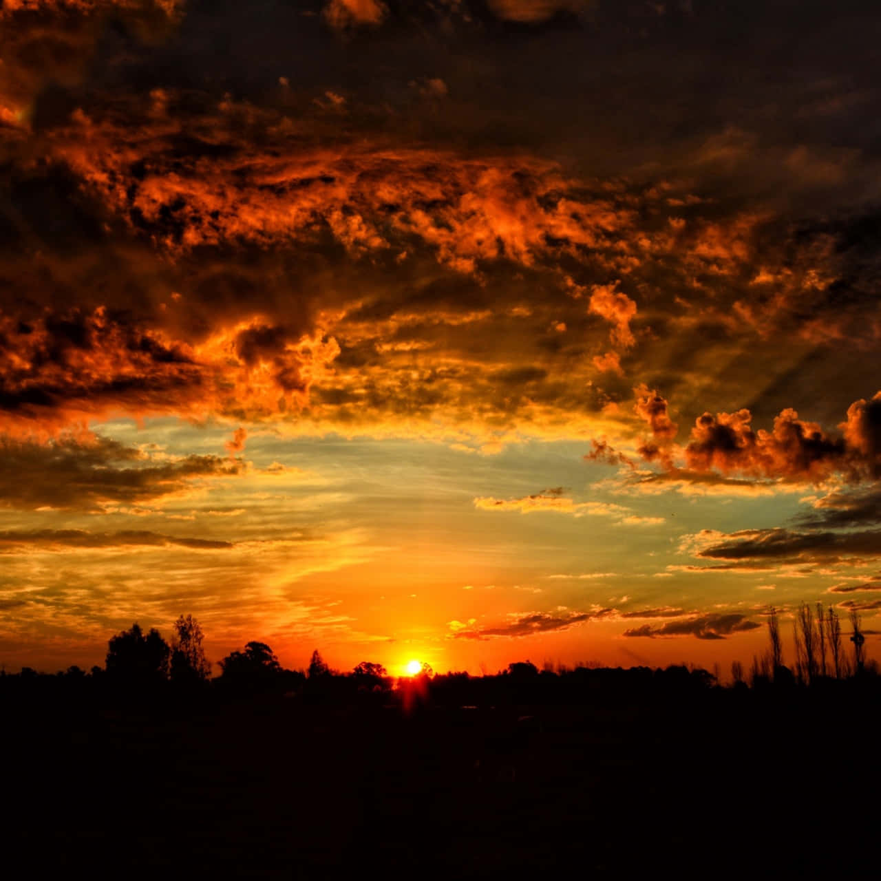 Majestic Orange Sunset Behind Dusky Clouds