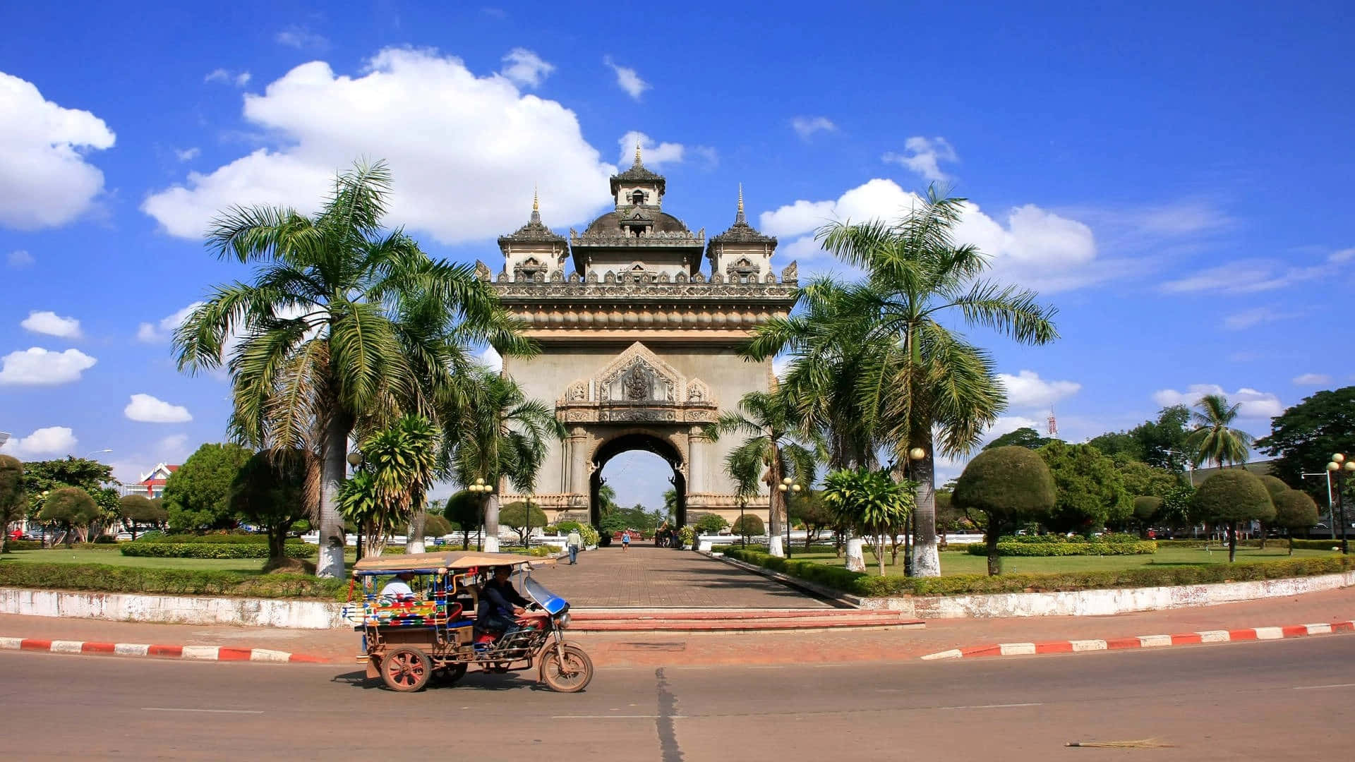 Majestic Patuxai Monument With Passing Vehicle In Vientiane, Laos Background