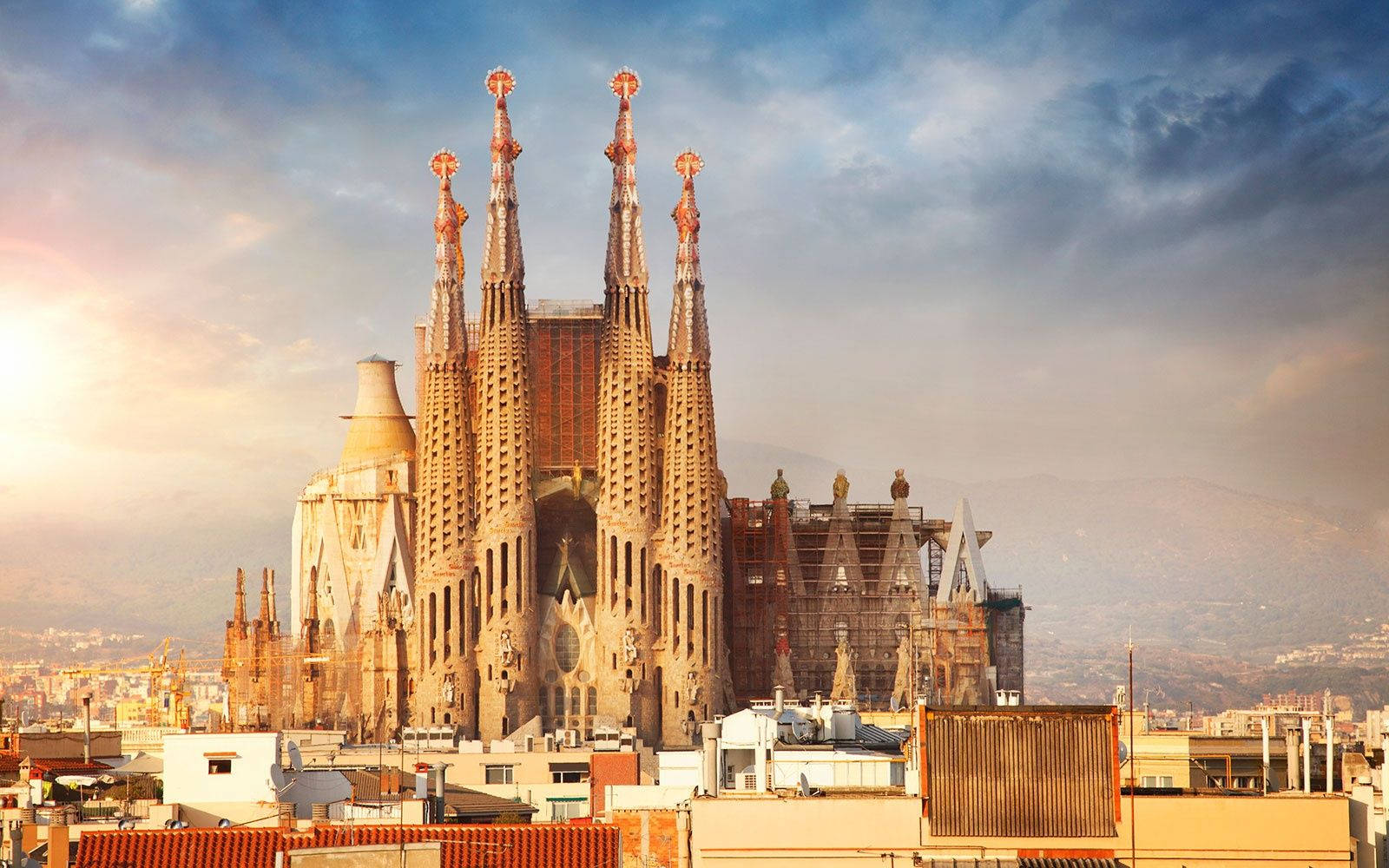 Majestic Sagrada Familia Under The Orange Evening Sky Background