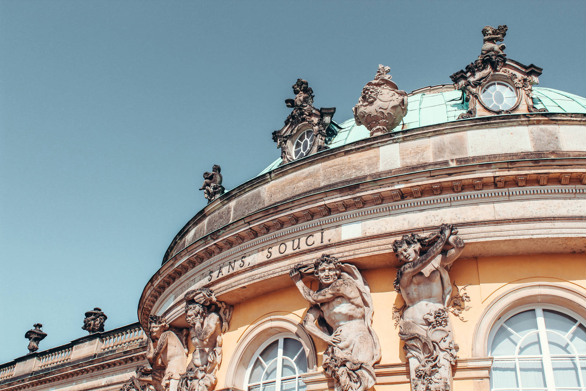 Majestic Sculptures Adorning The Rooftop Of Sanssouci Palace, Potsdam Background