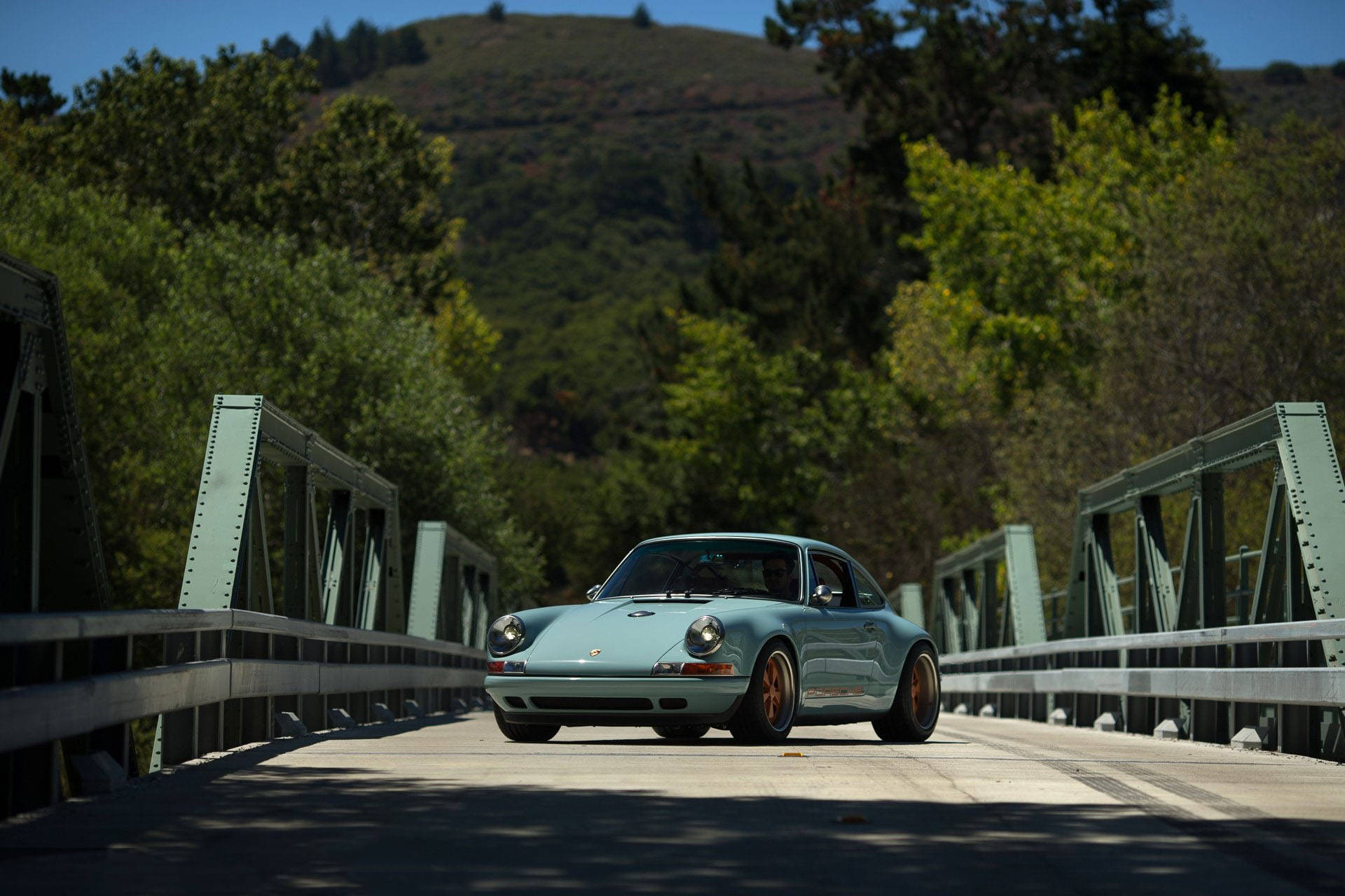 Majestic Singer Porsche Awaiting Adventure On The Bridge Background