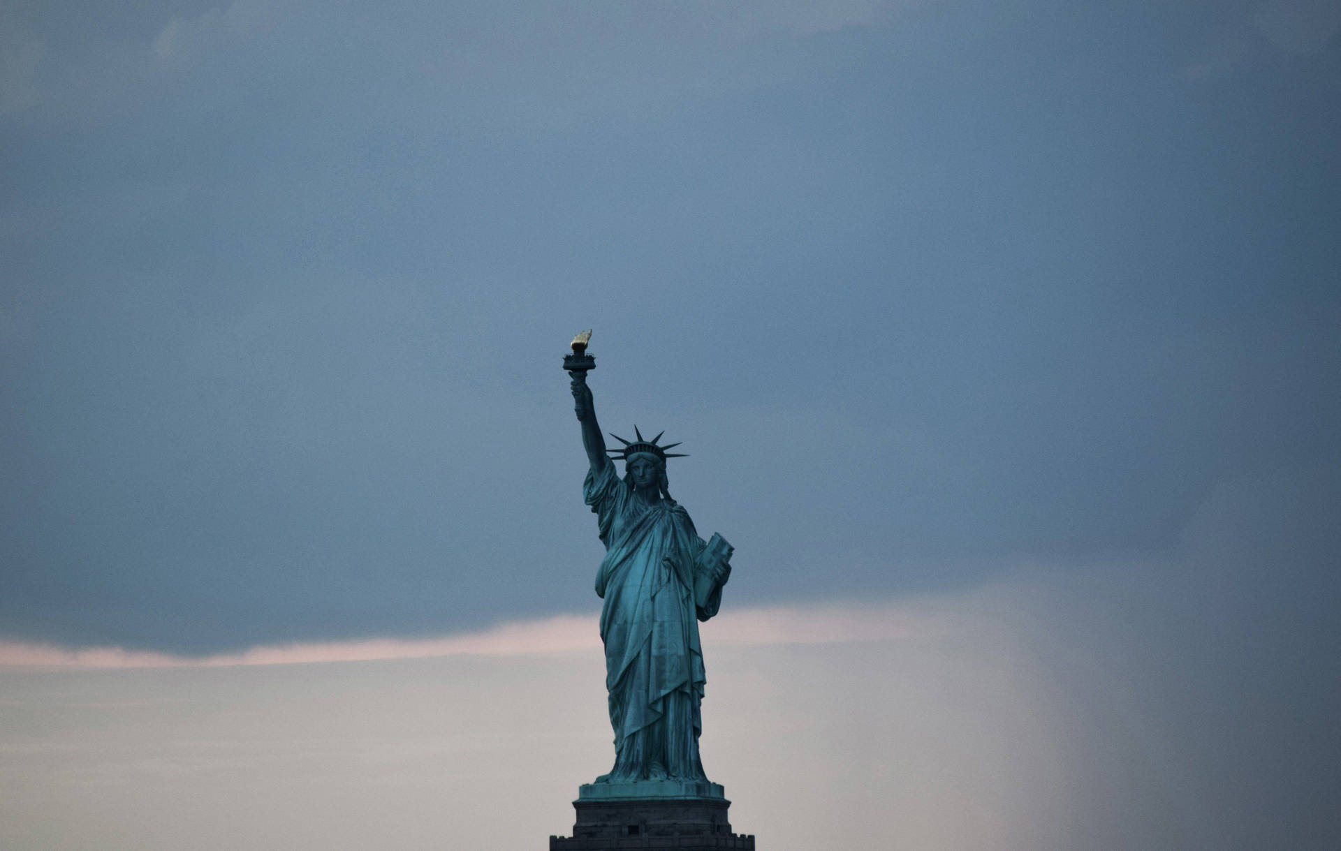 Majestic Statue Of Liberty Against A Gray Sky