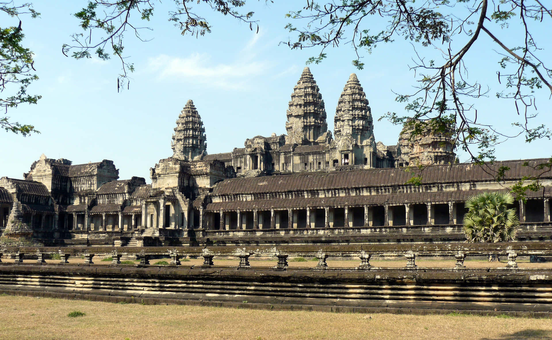 Majestic Stone Ruins Of Angkor Thom Against A Clear Blue Sky