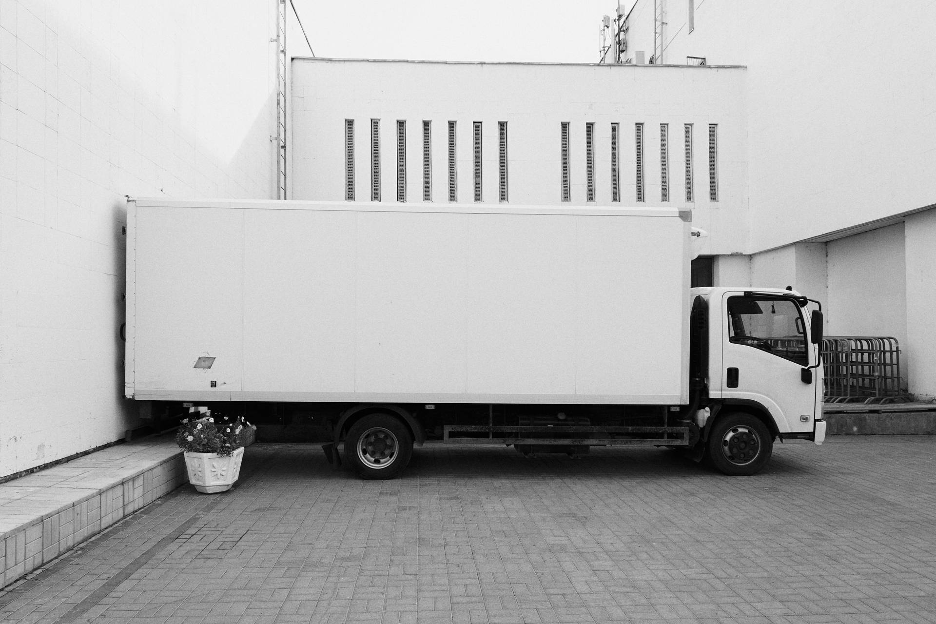 Majestic Trailer Truck Parked At A Commercial Building Background