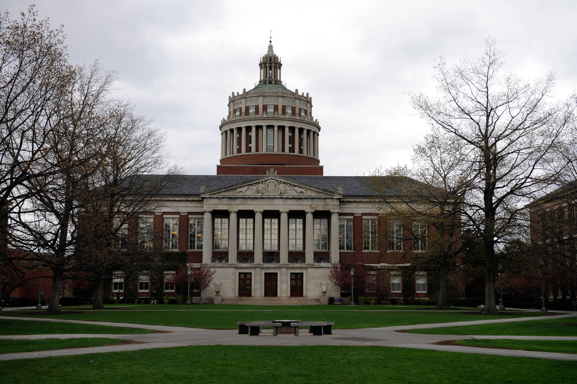 Majestic View Of The University Of Rochester Library Under A Gray Sky Background