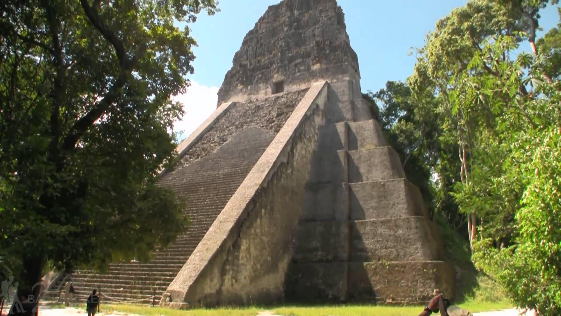 Majestic View Of Tikal Pyramid Basking Under A Bright Sun Background