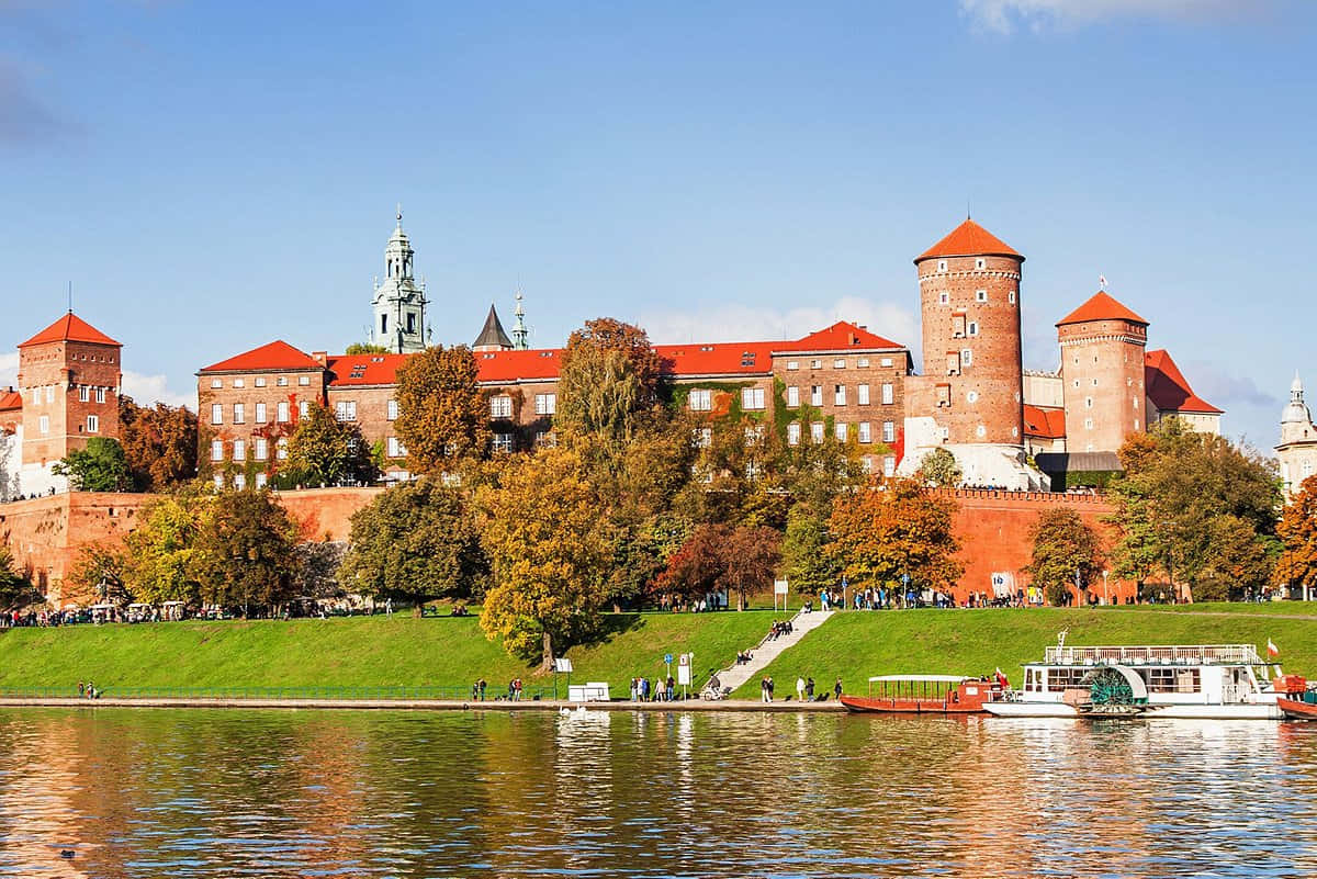 Majestic View Of Wawel Castle With Parked Boats On Vistula River, Poland