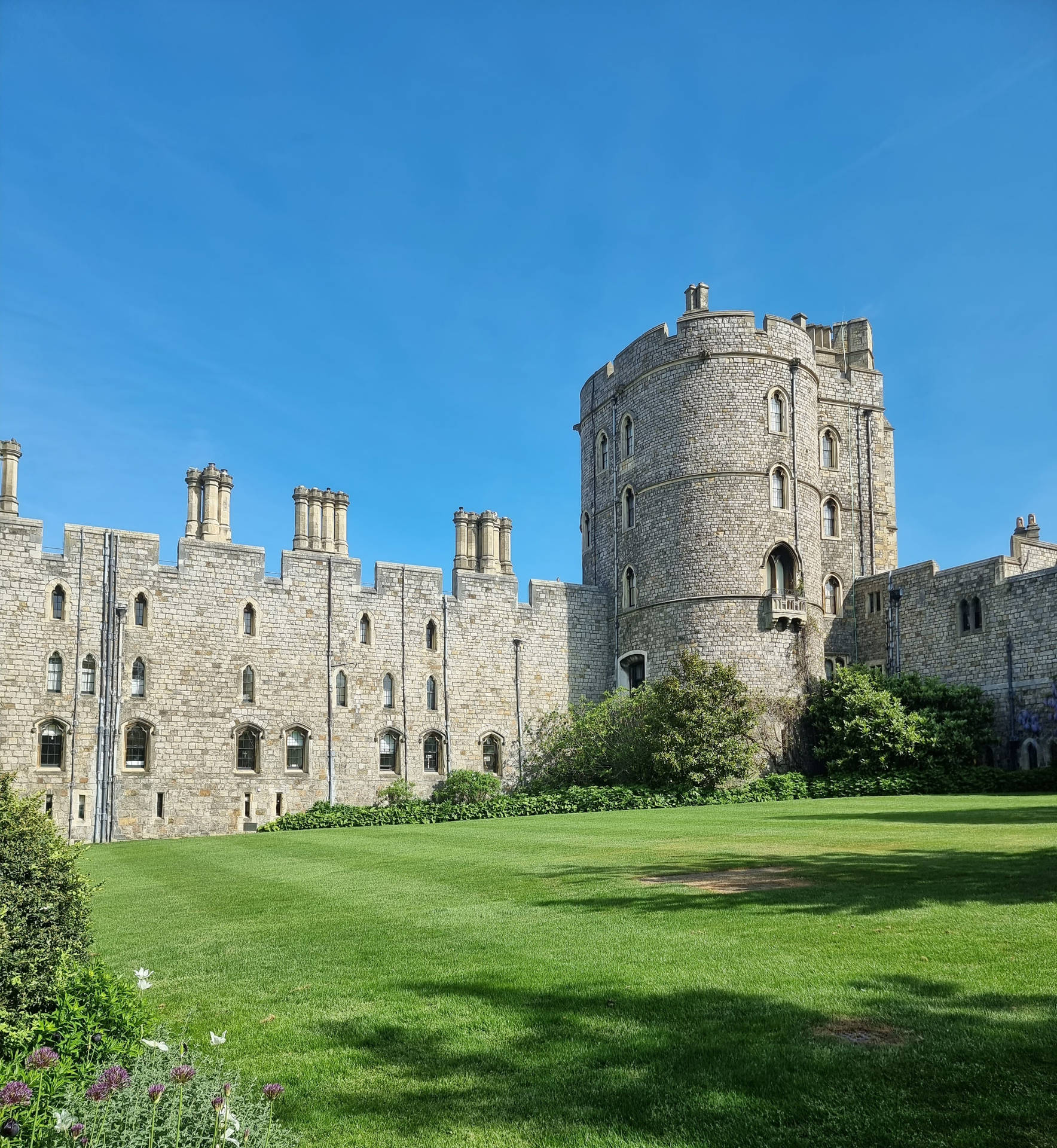 Majestic Windsor Castle Towering Over Green Meadow Background