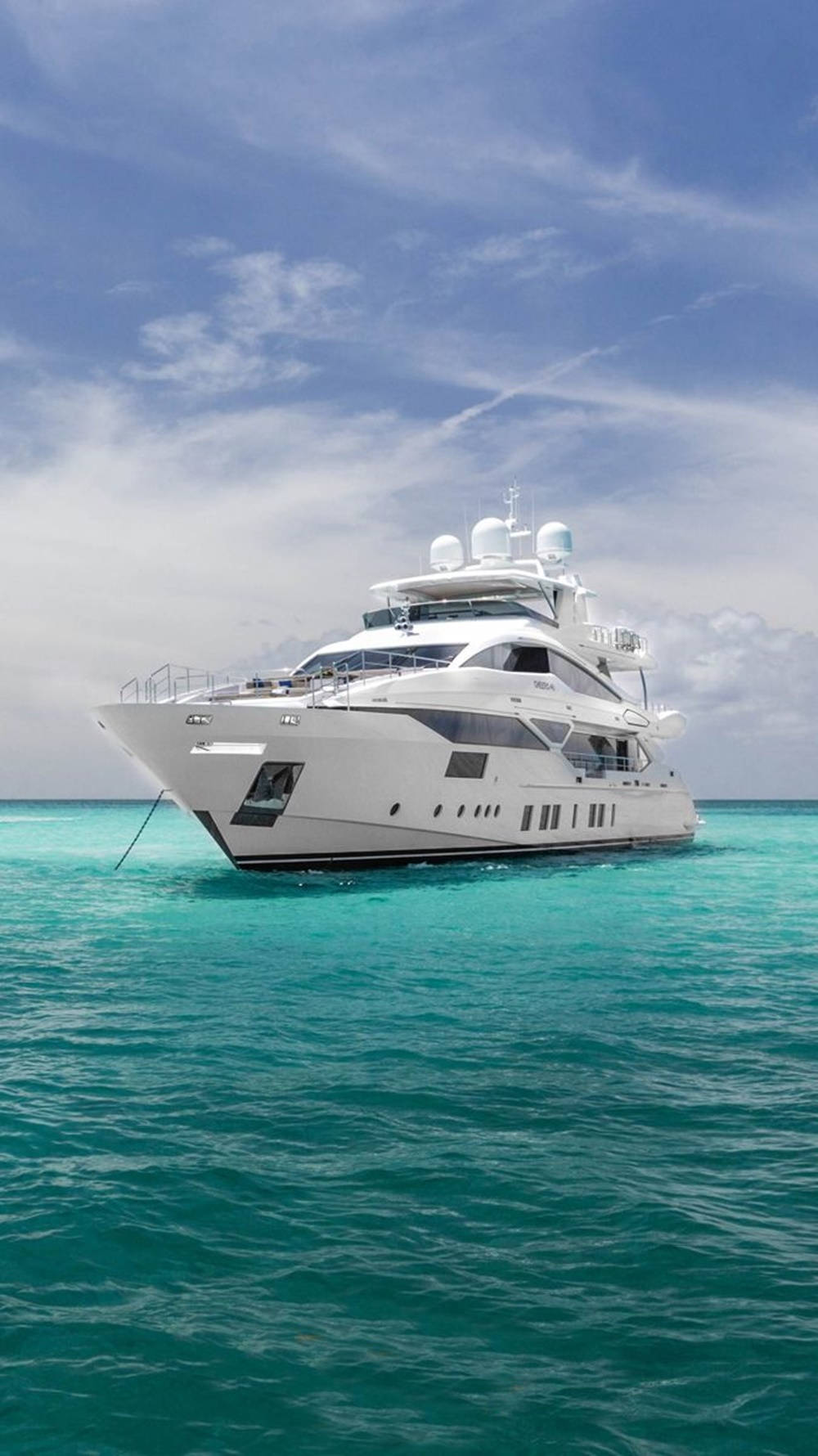 Majestic Yacht Sailing Under A Cloudy Blue Sky Background