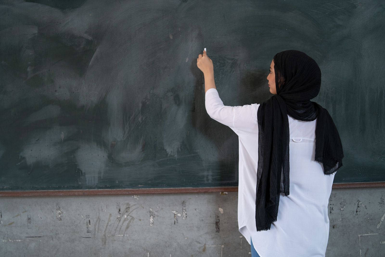 Malaysian Teacher Writing On Blackboard