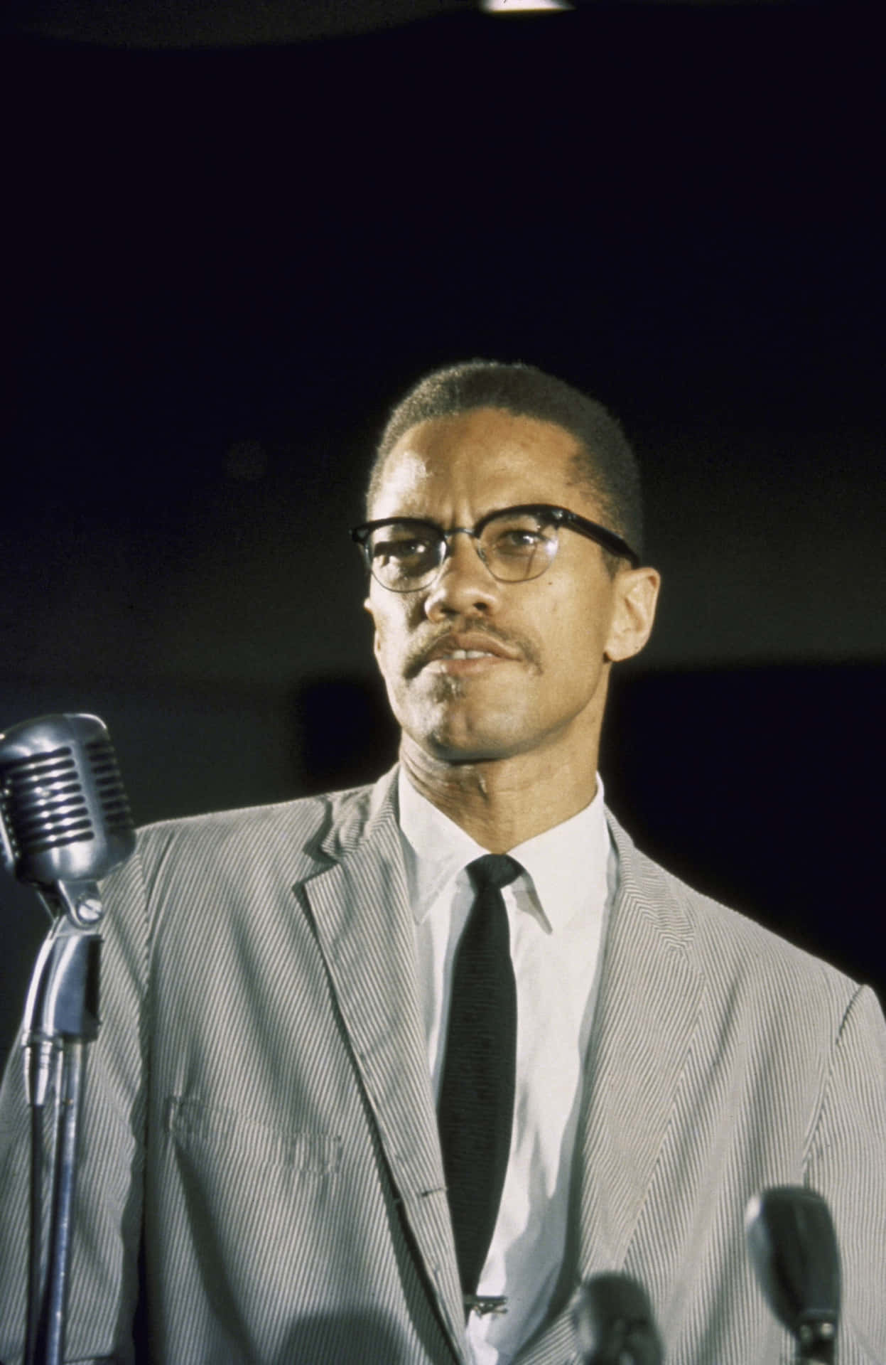 Malcolm X Speakingat Podium Background