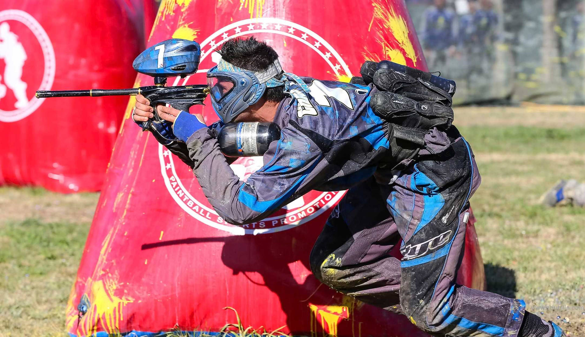 Man Beside Red Inflatable Paintball Bunker