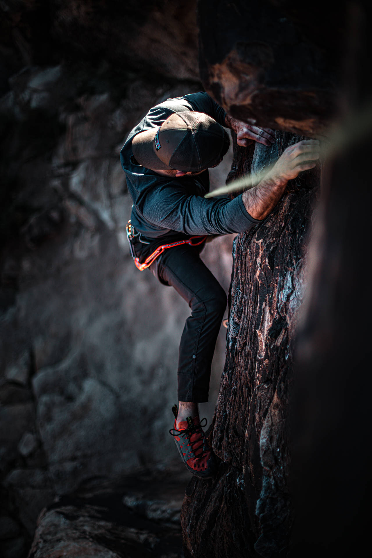 Man Climbing On A Dark Rock Structure