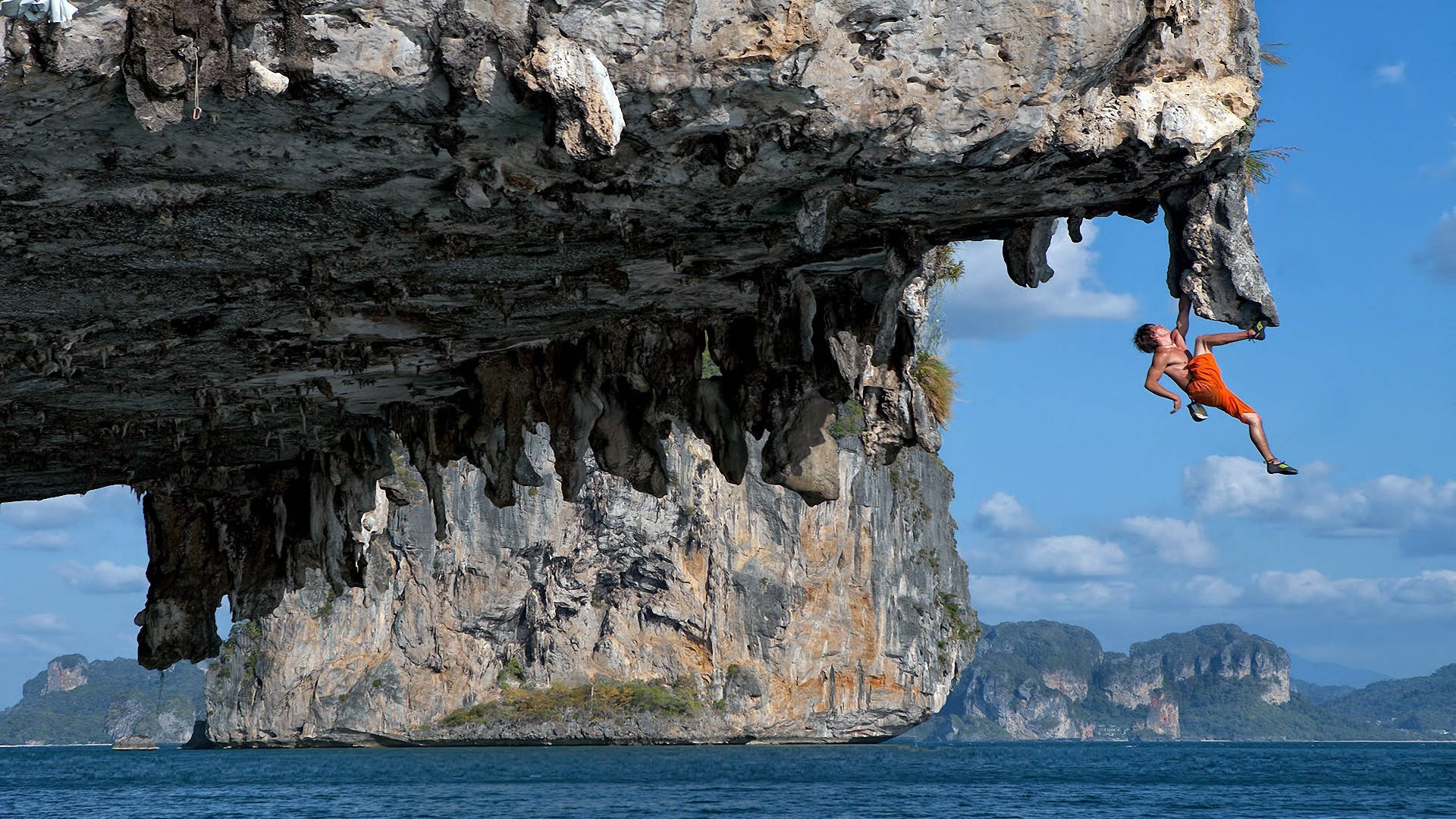 Man Climbing Rock Cave Near The Ocean