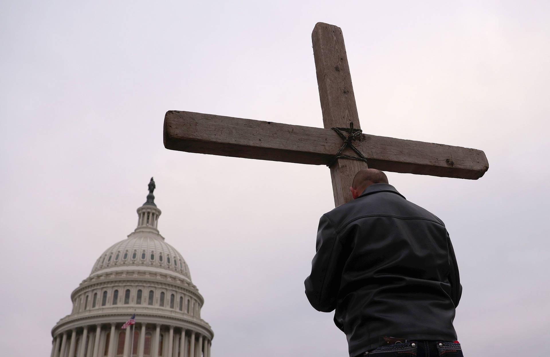 Man Clutching Christian Cross Symbols Background