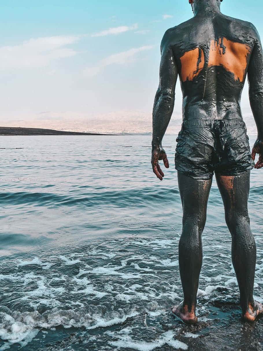 Man Covered In Dead Sea Mud Background