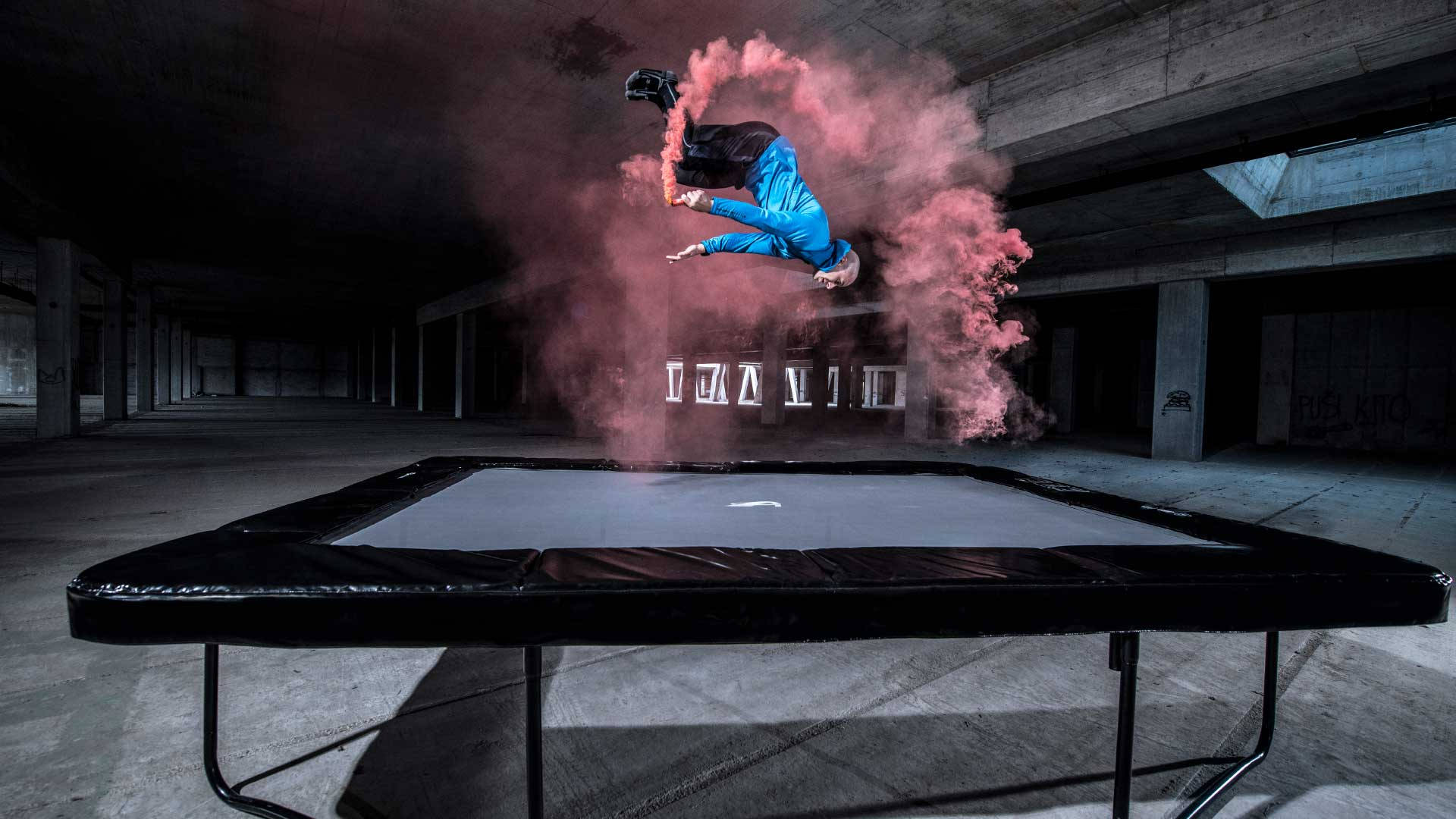 Man Doing An Acrobat On A Trampoline With Smoke