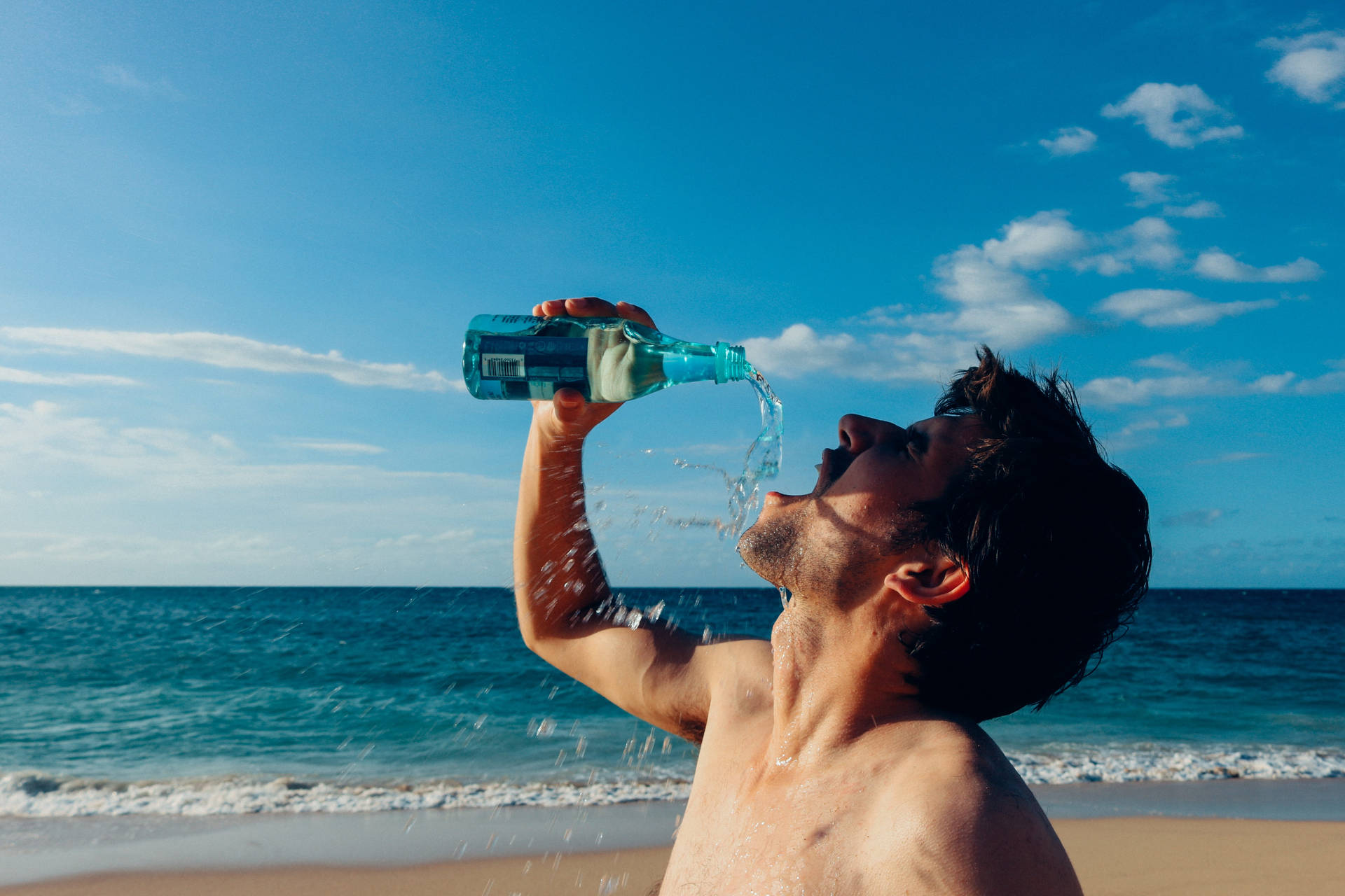 Man Drinking Water By The Sea Background